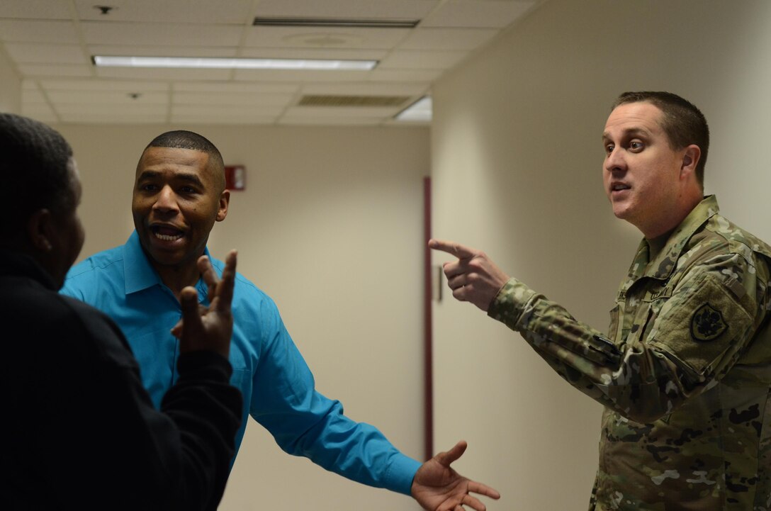 Sidney A. Williams Jr., the support services supervisor for the Defense Information School on Fort Meade, argues Jan. 28 with Russell Rush, who also works for the directorate of logistics at DINFOS, and Staff Sgt. Michael Sparks, an instructor at the school, about who will win the Super Bowl. Williams is a fan of the Carolina Panthers, who defeated the Seattle Seahawks – the team Sparks supports – in January in a divisional playoff game. The Panthers are scheduled to play the Denver Broncos on Feb. 7 in the Super Bowl.