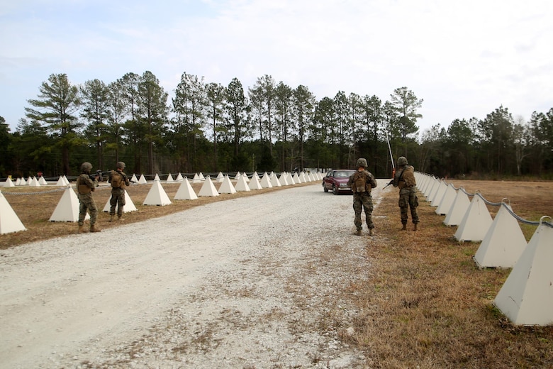 Marines with 2nd Transportation Support Battalion stop a vehicle as it enters the simulated Forward Operating Base Greater Sandy Runs Area during a tactical operations package with Battle Skills Training School, 2nd Marine Logistics Group, at Camp Lejeune, N.C., Feb. 3, 2016. The course is conducted to refresh Marines from non-infantry military occupational specialties on infantry-related skills and tactics in a five-week span. (U.S. Marine Corps photo by Cpl. Joey Mendez/Released)