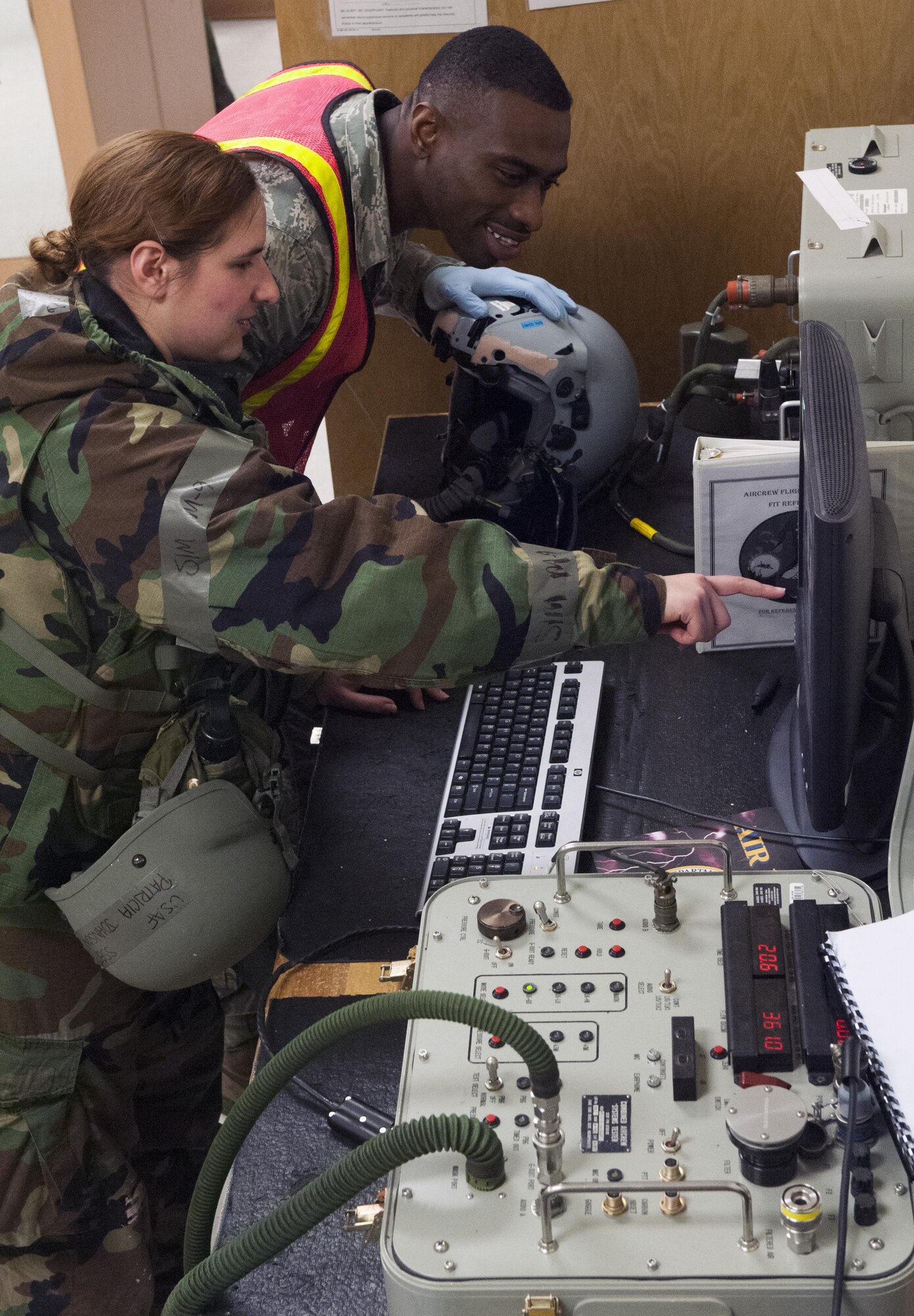 Staff Sgt. Patricia Johnson and Senior Airman Richmond Davis Jr., both 8th Operation Support Squadron aircrew flight equipment journeymen, test the serviceability of an F-16 Fighting Falcon pilot’s helmet during Beverly Pack 16-2 at Kunsan Air Base, Republic of Korea, Feb. 4, 2015. Though the exercise was planned for months, Airmen were not told when it would start, testing their readiness and ability to respond to a crisis at a moment's notice. (U.S. Air Force photo by Staff Sgt. Nick Wilson/Released)