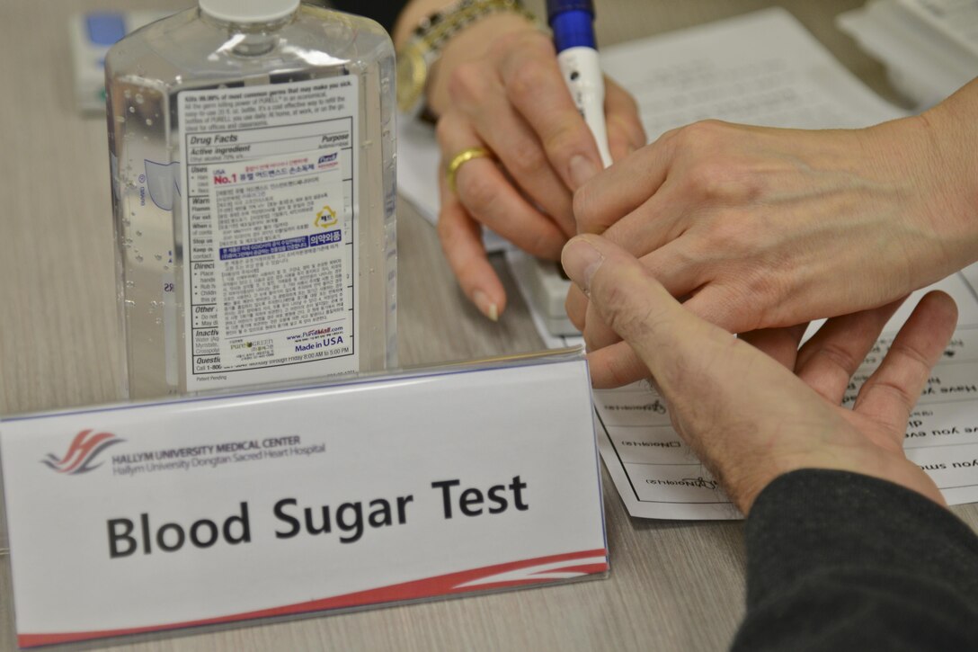 A nurse from the Hallym University Dongtan Sacred Heart Hospital pierces the finger of a retiree to test his blood sugar for diabetes during the Retiree Appreciation Day in the Exchange at Osan Air Base, Republic of Korea, Feb. 4, 2016. The blood-sugar test was one of six stations available to retirees during the free health screening. (U.S. Air Force photo by Tech. Sgt. Travis Edwards/Released)