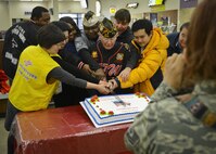 Retirees, volunteers and members of the Hallym University Dongtan Sacred Heart Hospital cut a cake together while getting their picture taken during the Retiree Appreciation Day in the Exchange at Osan Air Base, Republic of Korea, Feb. 4, 2016. Four volunteers from Team Osan planned the event in order to give back to the retired population for their continued support of local community. (U.S. Air Force photo by Tech. Sgt. Travis Edwards/Released)