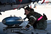 Tech. Sgt. Danielle Lynch, 4th Maintenance Group squadron lead crew, loads a simulated bomb onto an F-15E Strike Eagle during exercise Coronet Warrior 16-1, Feb. 1, 2016, at Seymour Johnson Air Force Base, North Carolina. Maintenance personnel were tested on their ability to generate aircraft for takeoff during elevated force protection conditions and mission orientated protective postures. (U.S. Air Force photo/Airman Shawna L. Keyes)