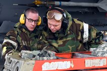 Two Airmen from the 4th Aircraft Maintenance Squadron review a pre-flight check list during exercise Coronet Warrior 16-01, Feb. 1, 2016, at Seymour Johnson Air Force Base, North Carolina. The exercise was conducted over two days and allowed wing inspection team members to evaluate Airmen’s preparedness for chemical warfare. (U.S. Air Force photo/Airman Shawna L. Keyes)