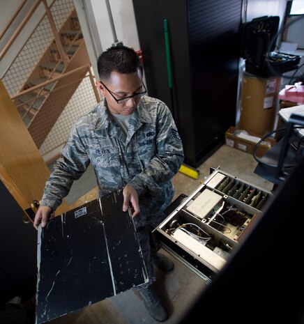 Staff Sgt. Michael Reyes, 437th Operations Support Squadron airfield systems technician, removes the cover of a radio system Jan. 27, 2016, at the command tower on Joint Base Charleston – North Auxiliary Air Field, S.C. 