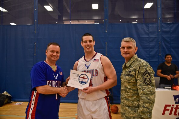 Capt. Daniel Winningham, 93rd Air Refueling Squadron pilot, receives a certificate from Col. Brian McDaniel, 92nd Air Refueling Wing commander, and Chief Master Sgt. Christian Pugh, 92nd ARW command chief, for winning the slam dunk contest during the first All-Star Basketball game Feb. 3, 2016, at Fairchild Air Force Base, Wash. Winningham received first place for gaining the highest scores against three other players. (U.S. Air Force photo/Airman 1st Class Taylor Bourgeous) 
