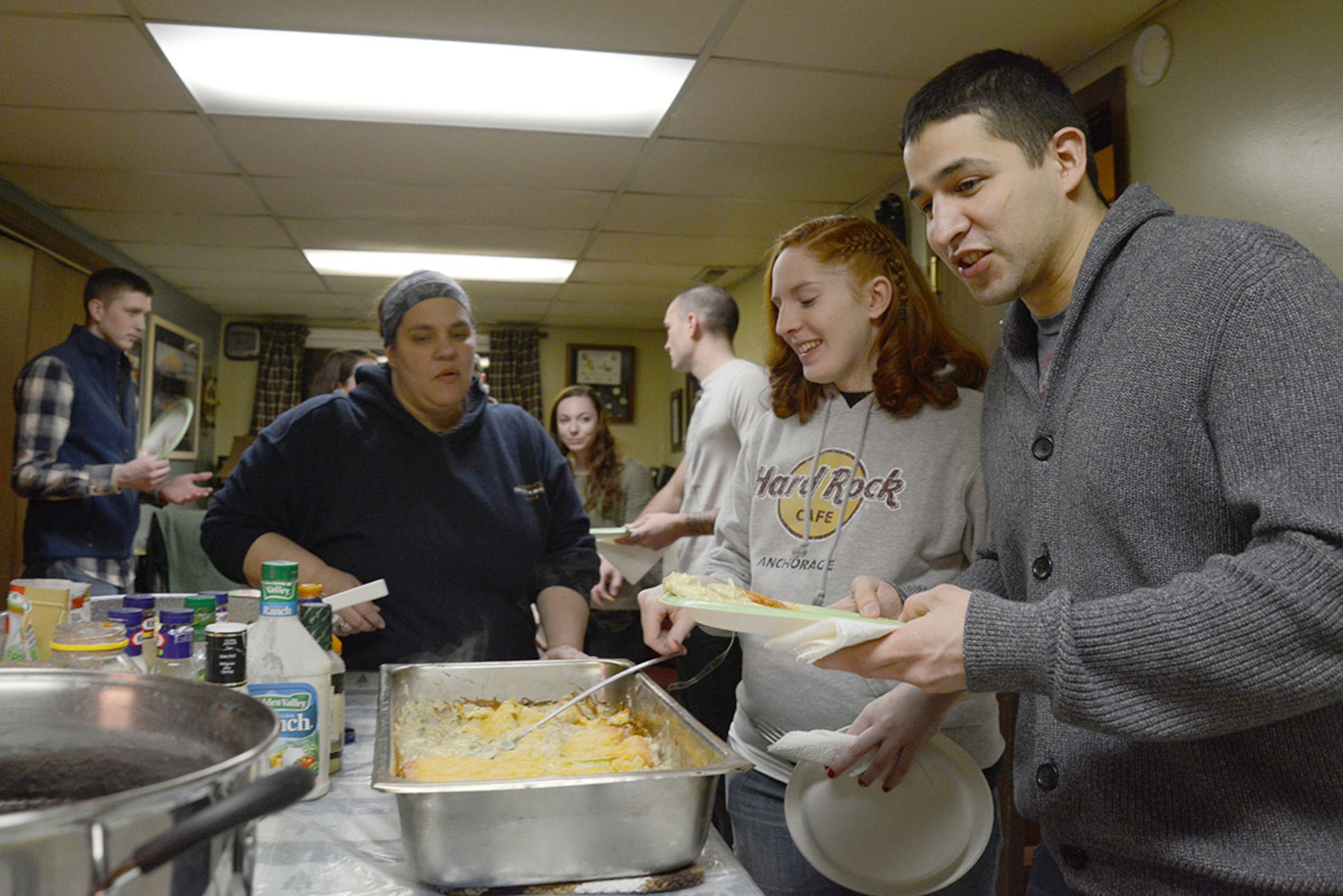 Senior Airman Humberto Sanchez, 673d Comptroller Squadron financial management accountant, fills his plate with food at the Mountain Chapel Hospitality House in Eagle River, Alaska, Jan. 22, 2016. Bob and Stephanie Caudle provide a free meal, usually in cooperation with other participants, for guests. (U.S. Air Force photo by Airman 1st Class Christopher R. Morales)