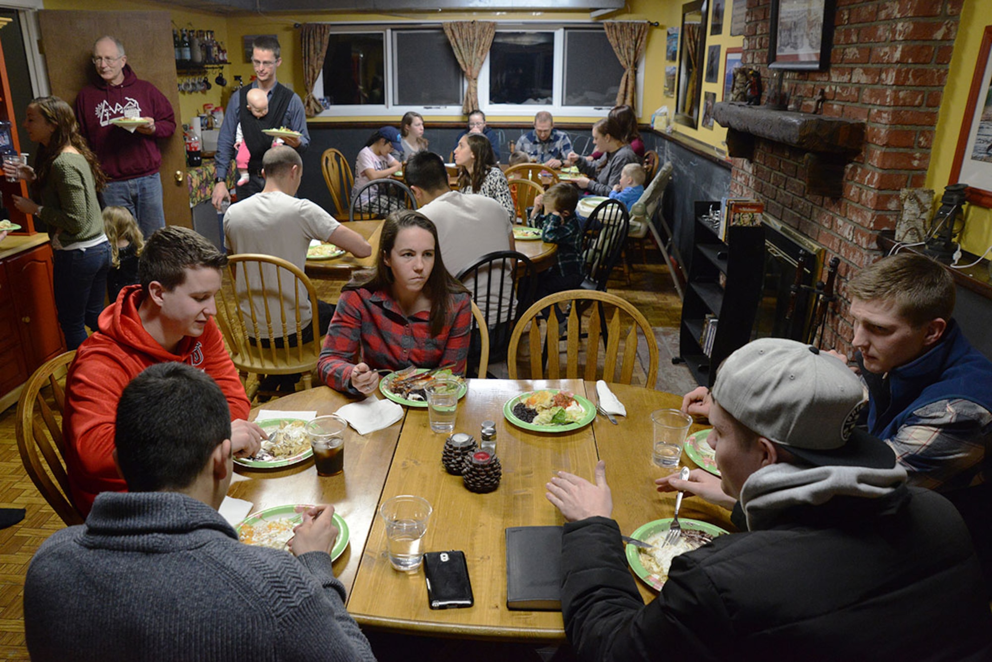 Mountain Chapel Hospitality House participants dine together at Bob and Stephanie Caudle’s hospitality house in Eagle River, Alaska, Jan. 22, 2016. Bob and Stephanie Caudle provide a free meal, usually in cooperation with other participants, for guests. (U.S. Air Force photo by Airman 1st Class Christopher R. Morales)