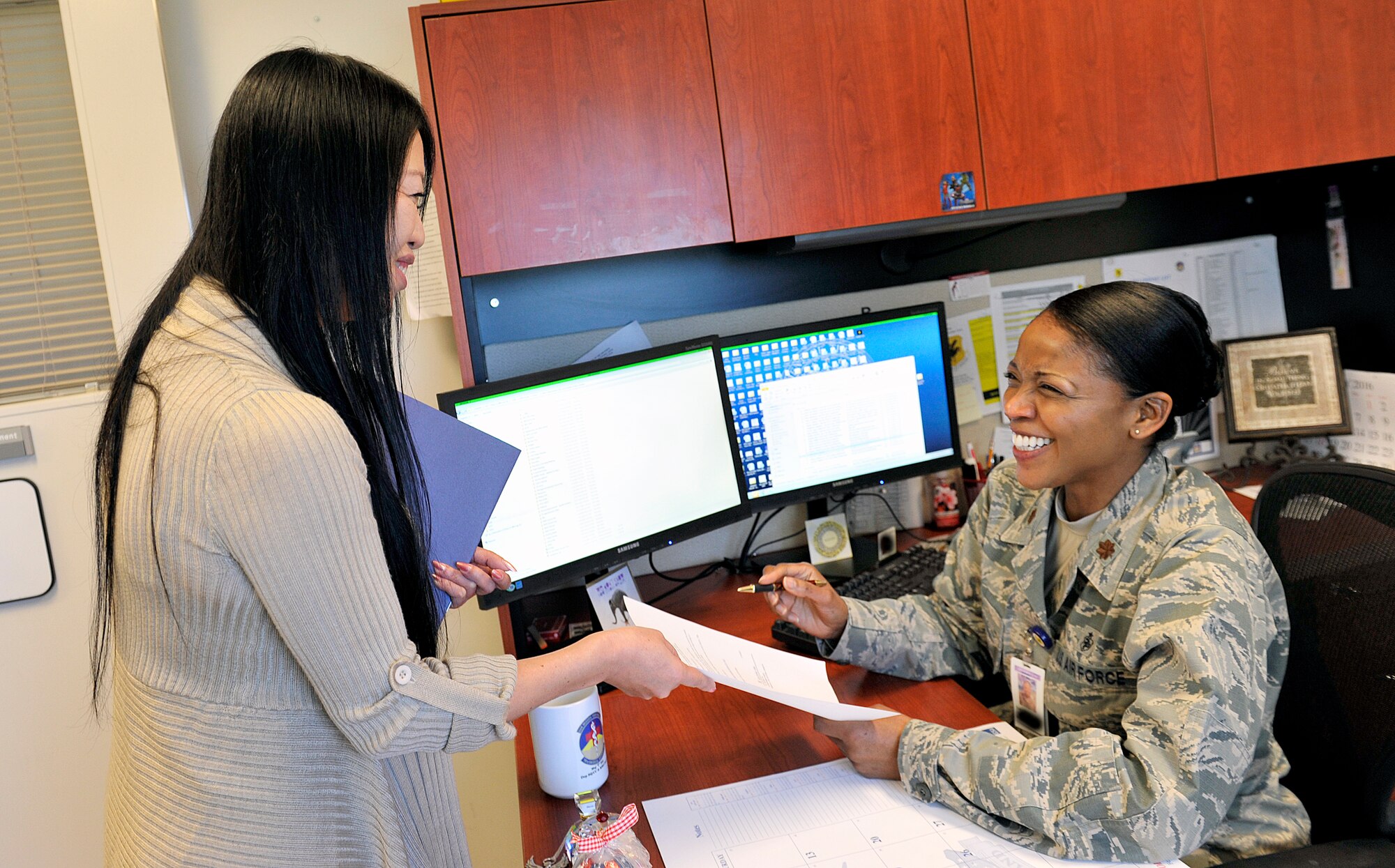 Mie Nagano, 18th Medical Support Squadron personnel manpower coordinating clerk, shows a request for personnel action to U.S. Air Force Maj. Theodosia Hill, 18th MDSS resource management office flight commander, Feb. 4, 2016, at Kadena Air Base, Japan. Nagano's goal at 18th MDSS is to perfect her skills as a personnel clerk and to be able to handle any case. (U.S. Air Force photo by Naoto Anazawa)

