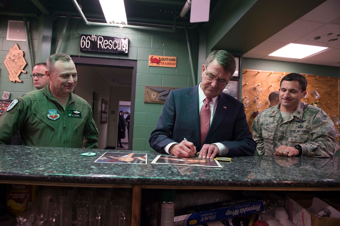 Defense Secretary Ash Carter, center, autographs a photo at the 66th Rescue Squadron headquarters on Nellis Air Force Base, Nev., Feb. 4, 2016. DoD photo by Navy Petty Officer 1st Class Tim D. Godbee