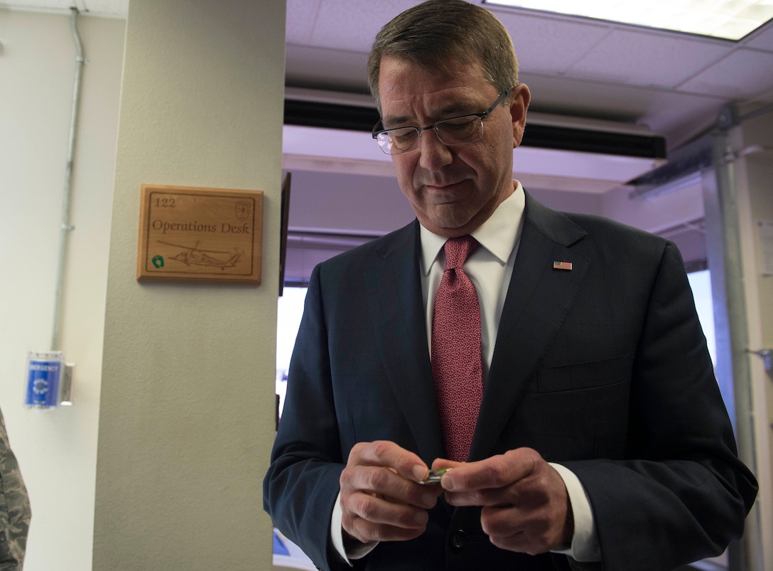 Defense Secretary Ash Carter receives a challenge coin from the 66th Rescue Squadron on Nellis Air Force Base, Nev., Feb. 4, 2016. DoD photo by Navy Petty Officer 1st Class Tim D. Godbee