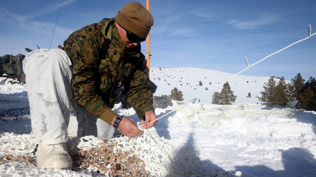 Cpl. Robert Schmitt sews an Arctic camouflage net during cold weather training at Marine Corps Mountain Warfare Training Center, California, Jan. 21, 2016. The cold weather training done in the Sierra Mountains is a warm-up to Exercise Cold Response 1-16 in Norway. Nearly 80 Marines with 2nd LAAD Bn. participated in the two-weeklong exercise that taught basic mobility in snow, defensive and offensive tactics as well as basic cold weather and high altitude conditions training.