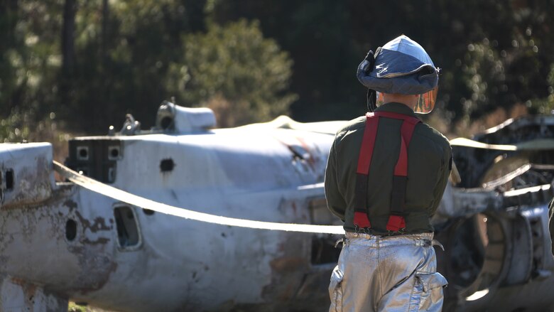 Lance Cpl. Jacob Davis ties down an aircraft during an aircraft recovery training exercise at Marine Corps Auxiliary Landing Field Bogue, N.C., Feb. 2, 2016. Aircraft rescue and firefighting Marines, heavy equipment operators, bulk fuels specialists,  motor transportation Marines and combat engineers with Marine Wing Support Squadron 274 worked hand-in-hand to retrieve a simulated downed aircraft. They were given a scenario and were tasked to provide a security perimeter around the aircraft while securing and transporting the aircraft in a safe and effective manner. The ability to retrieve aircraft without the aid of outside resources increases the unit’s effectiveness and their expeditionary capabilities. Davis is a aircraft rescue firefighter with MWSS-274. 