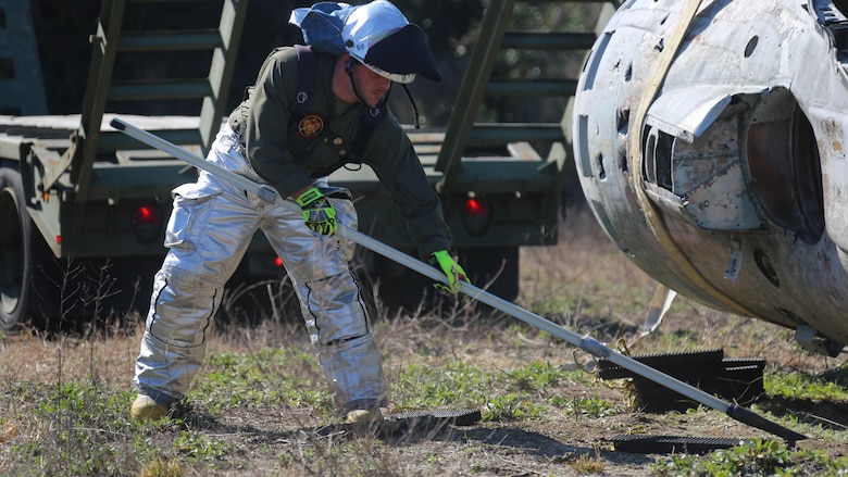 Lance Cpl. Jordan Hice clears debris during an aircraft recovery training exercise at Marine Corps Auxiliary Landing Field Bogue, N.C., Feb. 2, 2016. Aircraft rescue and firefighting Marines, heavy equipment operators, bulk fuels specialists,  motor transportation Marines and combat engineers with Marine Wing Support Squadron 274 worked hand-in-hand to retrieve a simulated downed aircraft. They were given a scenario and were tasked to provide a security perimeter around the aircraft while securing and transporting the aircraft in a safe and effective manner. The ability to retrieve aircraft without the aid of outside resources increases the unit’s effectiveness and their expeditionary capabilities. Hice is a aircraft rescue firefighter with MWSS-274. 