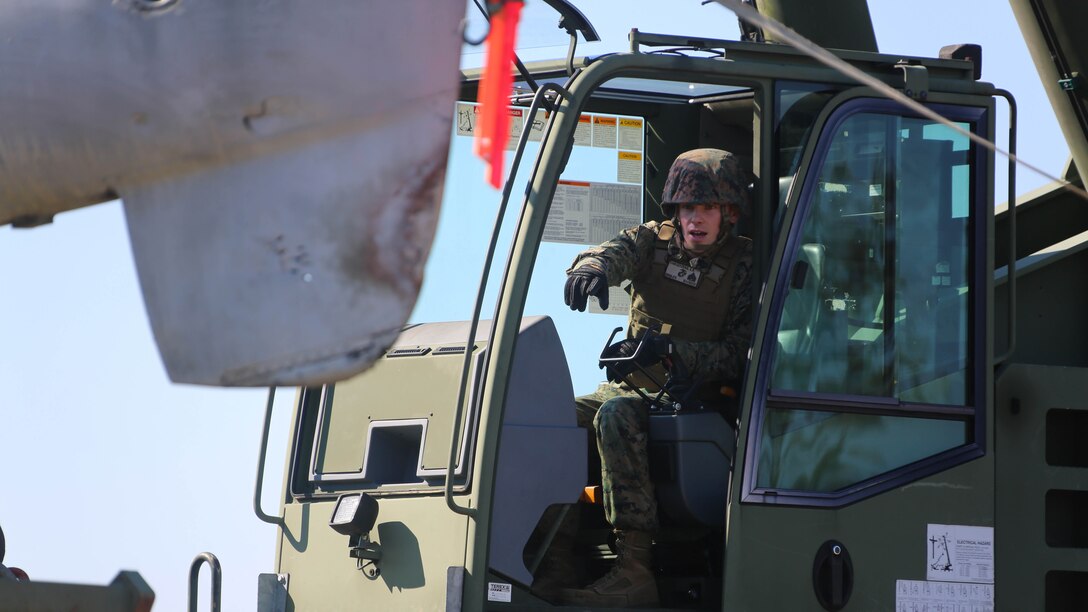 Sgt. Kevin Vankoevering directs Marines from a during an aircraft recovery training exercise at Marine Corps Auxiliary Landing Field Bogue, N.C., Feb. 2, 2016. Aircraft rescue and firefighting Marines, heavy equipment operators, bulk fuels specialists,  motor transportation Marines and combat engineers with Marine Wing Support Squadron 274 worked hand-in-hand to retrieve a simulated downed aircraft. They were given a scenario and were tasked to provide a security perimeter around the aircraft while securing and transporting the aircraft in a safe and effective manner. The ability to retrieve aircraft without the aid of outside resources increases the unit’s effectiveness and their expeditionary capabilities. Vankoevering is a heavy equipment operator with MWSS-274. 