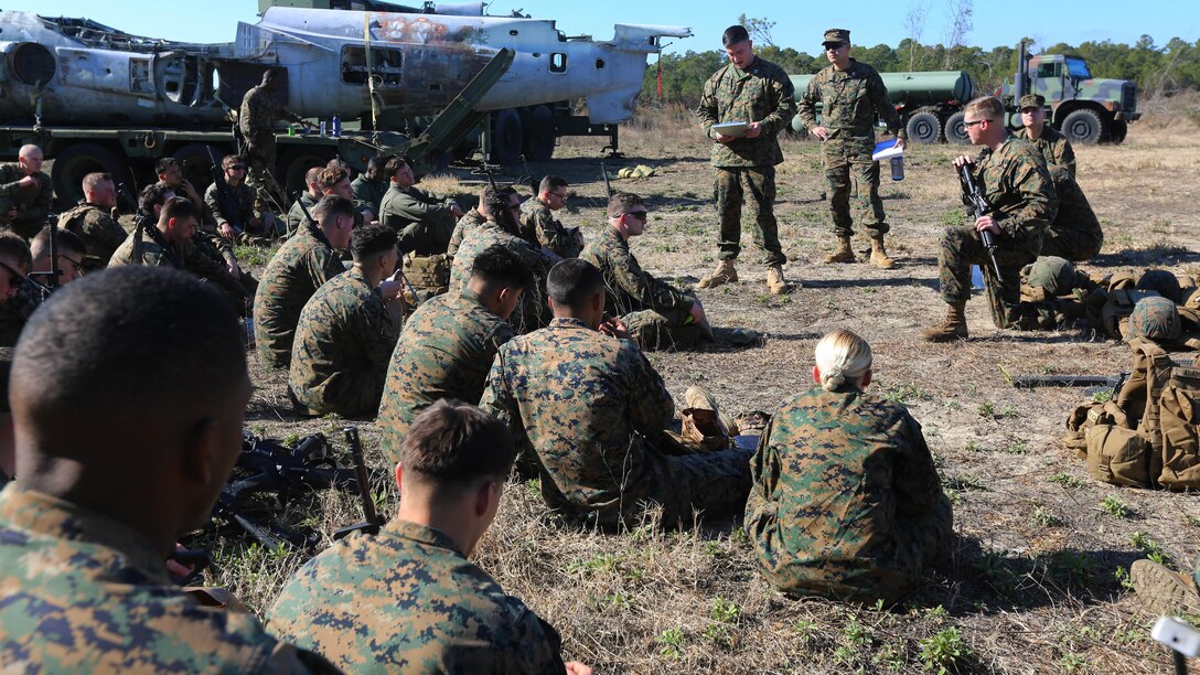 Marines gather for an after action report during an aircraft recovery training exercise at Marine Corps Auxiliary Landing Field Bogue, N.C., Feb. 2, 2016. Aircraft rescue and firefighting Marines, heavy equipment operators, bulk fuels specialists, motor transportation Marines and combat engineers with Marine Wing Support Squadron 274 worked hand-in-hand to retrieve a simulated downed aircraft. They were given a scenario and were tasked to provide a security perimeter around the aircraft while securing and transporting the aircraft in a safe and effective manner. The ability to retrieve aircraft without the aid of outside resources increases the unit’s effectiveness and their expeditionary capabilities.