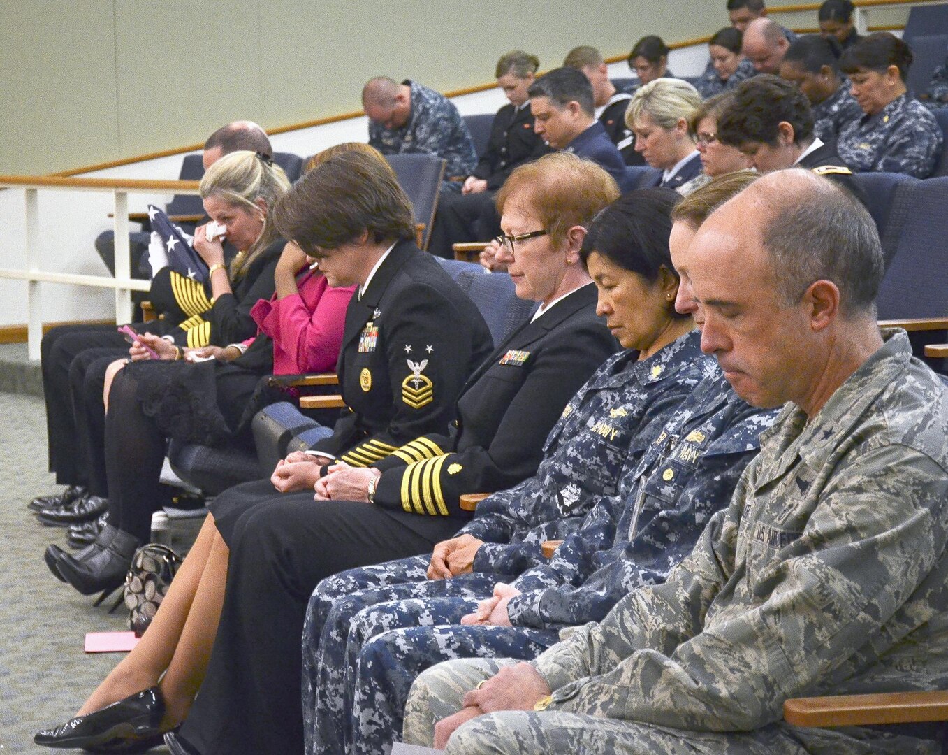 Senior Navy and Air Force personnel bow their heads during the benediction at a celebration of life memorial ceremony Jan. 25 at Joint Base San Antonio-Fort Sam Houston. The ceremony was held to remember Seaman Nenit Coltra, who worked at the Medical Education and Training Campus before she passed away Dec. 28, 2015, at 23 years old.