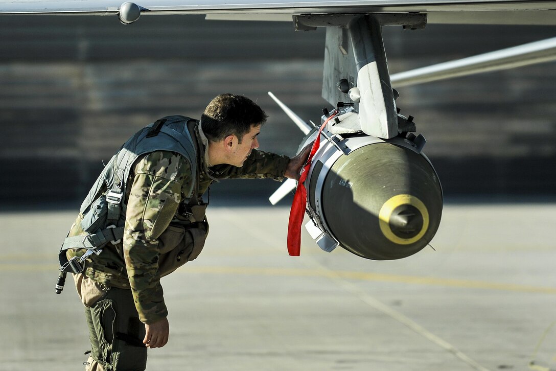 Air Force Lt. Col. Thomas Wolfe performs preflight checks on an F-16 Fighting Falcon carrying two guided bomb units on Bagram Airfield, Afghanistan, Feb. 1, 2016. Wolfe is the deputy commander for the 455th Expeditionary Operations Group. Air Force photo by Tech. Sgt. Nicholas Rau
