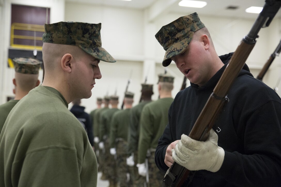 Lance Cpl. Cody McNeley, a Silent Drill School instructor, conducts baseline drill sequence training, called landing party manual, with a student at Joint Base Anacostia, Washington, D.C., Jan. 8, 2016. Each year from November to March the Silent Drill Platoon conducts Silent Drill School to hand-select new Marines for the upcoming parade season.  The selection process is conducted by Marines from previous years to identify Marines who will represent, on the parade deck, the professionalism associated with the Marine Corps. (Official Marine Corps photos by Cpl. Chi Nguyen/Released)