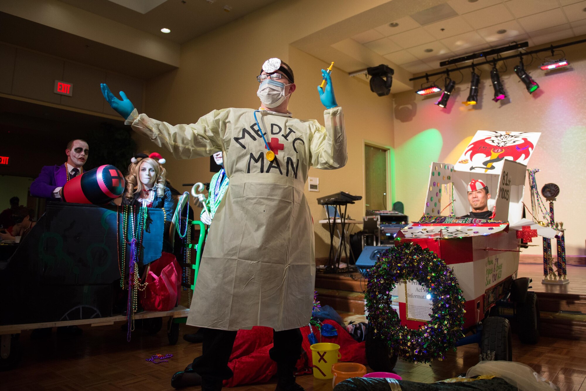 Senior Airman Justin Wright, 81st Medical Operations Squadron mental health technician, leads a Mardi Gras “float” during the 28th Annual Krewe of Medics Mardi Gras Ball at the Bay Breeze Event Center  Jan. 30, 2016, Keesler Air Force Base, Miss. The Krewe of Medics hosts a yearly ball to give military personnel assigned to the Keesler Medical Center a taste of the Gulf Coast and an opportunity to experience a traditional Mardi Gras. The theme of this year's ball was superheroes and villains. (U.S. Air Force photo by Marie Floyd)