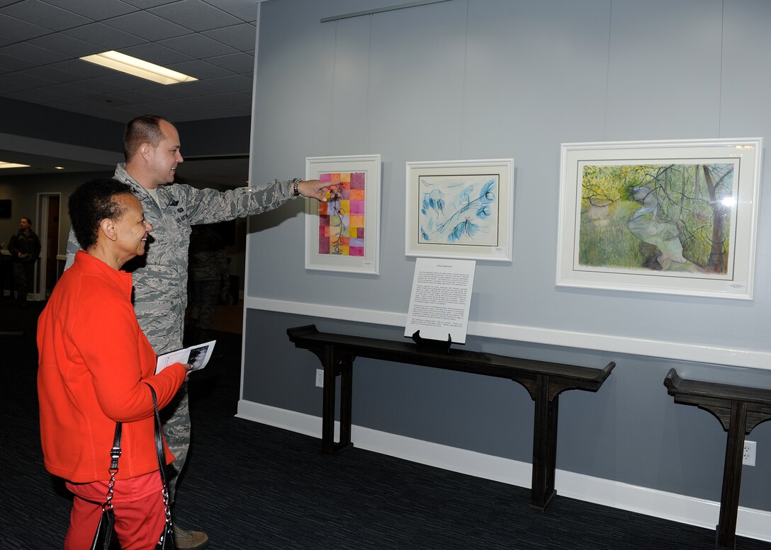 Col. John Nichols, 14th Flying Training Wing Commander, and Dianne James, 14th Mission Support Group Commander’s Secretary, view the art in the new art exhibit Feb. 1 in the Columbus Club on Columbus Air Force Base, Mississippi. The art currently featured is by Mississippi native Frances Hairston. (U.S. Air Force photo/Elizabeth Owens)