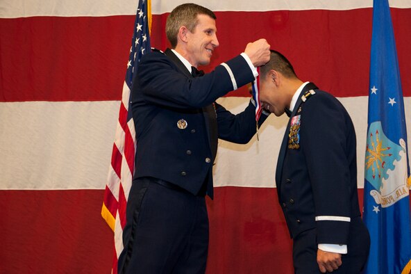 U.S. Air Force Col. Thomas Kunkel, 23d Wing commander, places a medallion around the neck of Maj. Thang Nguyen, 23d Mission Support Group operations flight commander, during a medallion ceremony, Feb. 4, 2016, at Moody Air Force Base, Ga. The medallion ceremony was held before the start of the 2015 Annual Awards Ceremony to individually recognize each nominee. (U.S. Air Force photo by Airman 1st Class Lauren M. Johnson/Released)