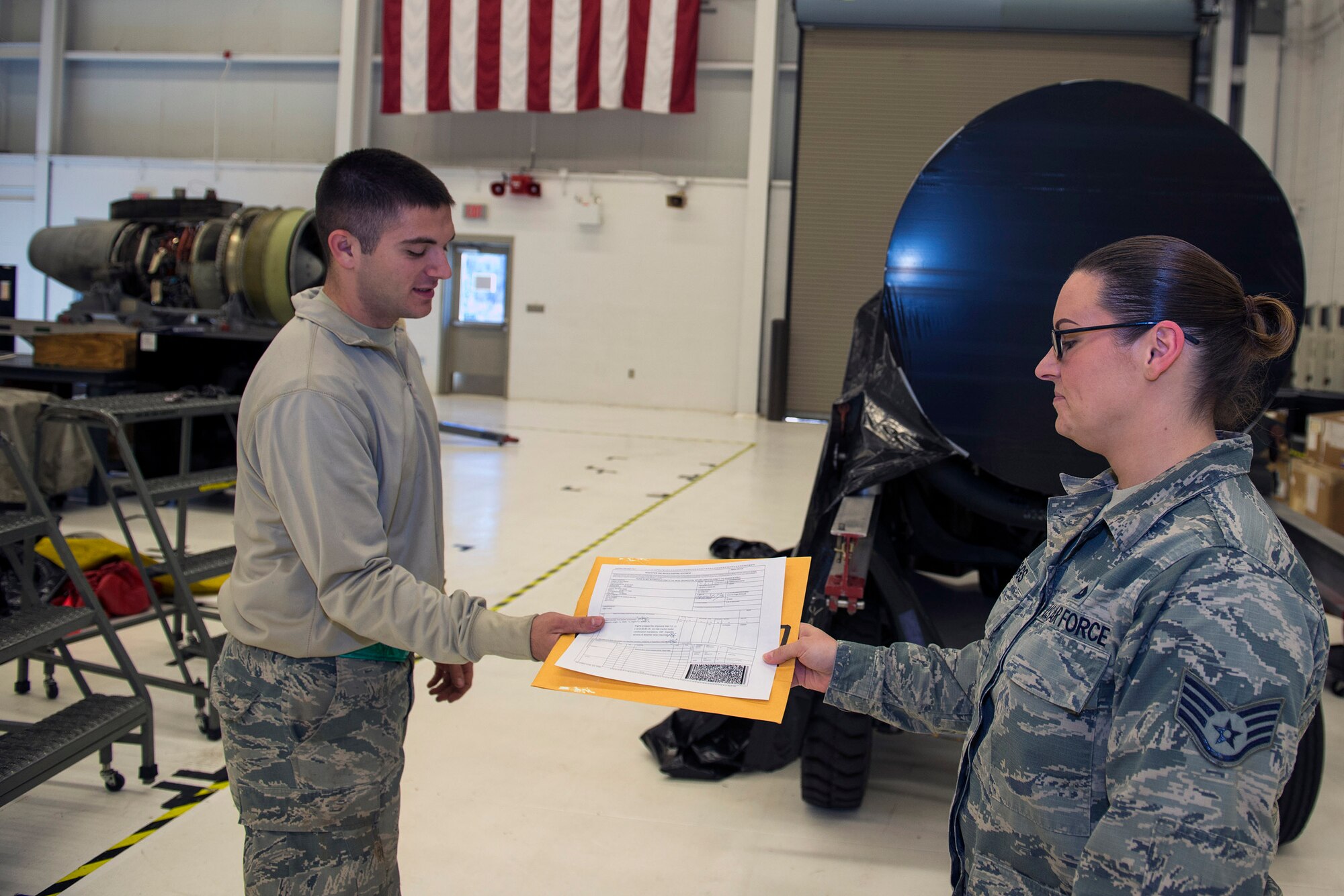 U.S. Air Force Senior Airman Anthony Armelli, 23d Component Maintenance Squadron aerospace propulsion flight journeyman, receives an Air Force Technical Order Form 95 from Staff Sgt. Amanda Griggs, 23d Maintenance Operations Flight engine management engine manager, Jan. 12, 2016, at Moody Air Force Base, Ga. The form contained a TF-34 engine’s maintenance history prior to transporting to Joint Base McGuire-Dix-Lakehurst, N.J., in support of the 74th Fighter Squadron. (U.S. Air Force photo by Airman 1st Class Greg Nash/Released