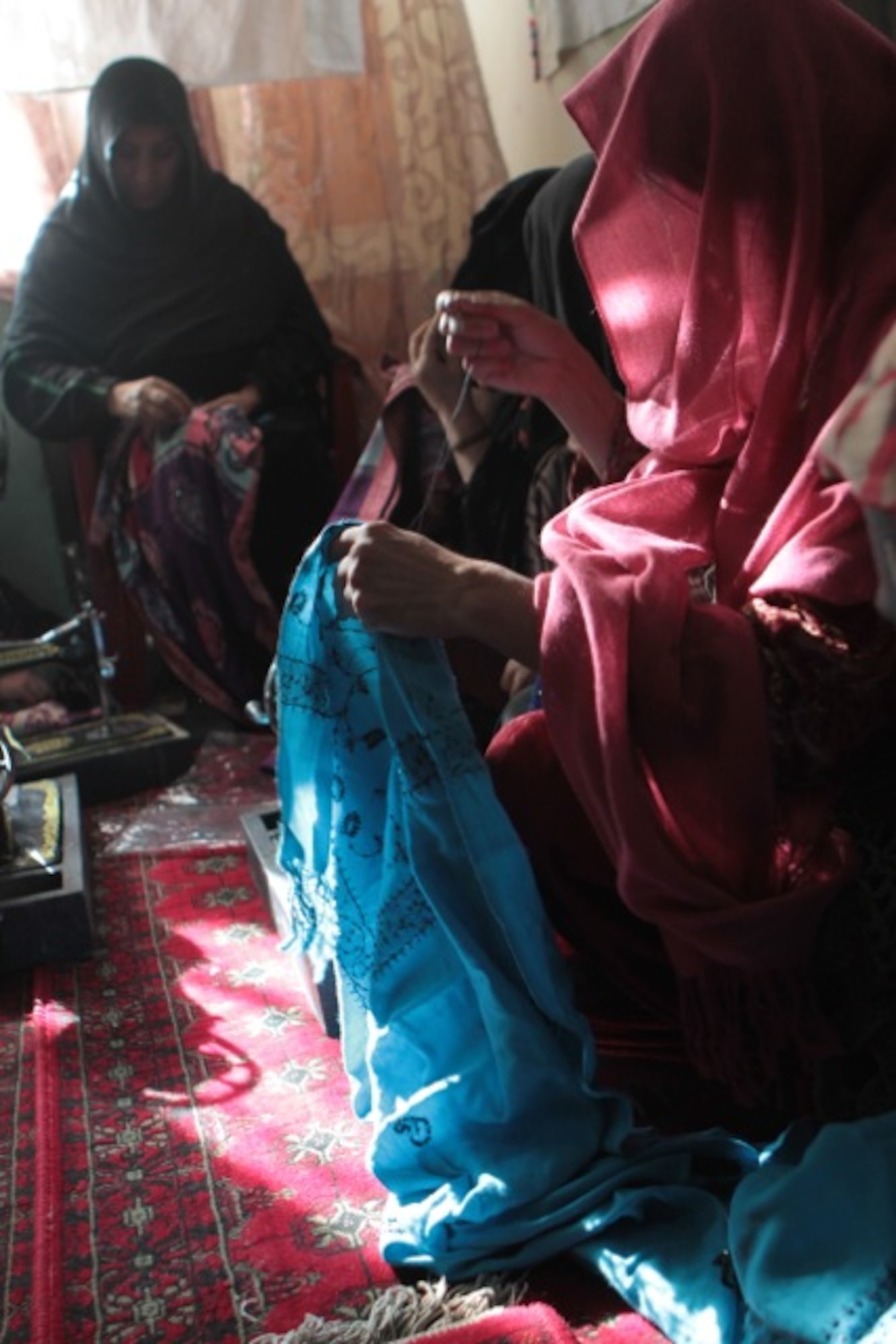 Several Afghan women sew scarves together to be sold through Flying Scarfs, a non-profit organization founded by four aviators while deployed to Bagram Airfield, Afghanistan, in 2011. Since its inception, Flying Scarfs has grossed more than $150,000 in revenue that goes directly back to Afghani women. (Courtesy photo) 