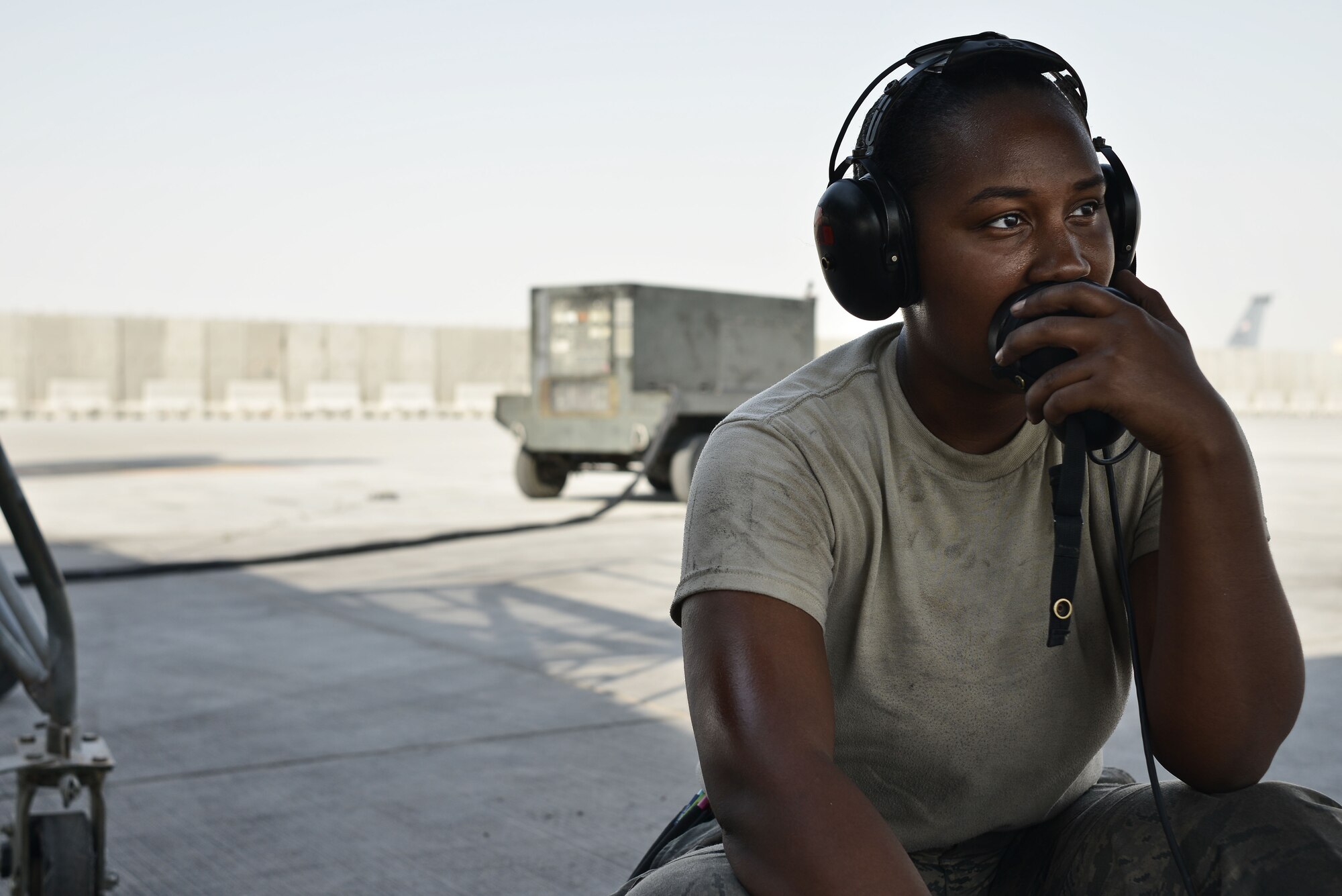 Airman 1st Class Sade, 28th Aircraft Maintenance Squadron crew chief, listens to another crew chief inside a B-1 bomber while completing operation checks during post-flight inspections Sept. 22, 2015 at Al Udeid Air Base, Qatar. Sade was deployed out of Ellsworth Air Force Base, S.D. (U.S. Air Force photo by Staff Sgt. Alexandre Montes/Released)