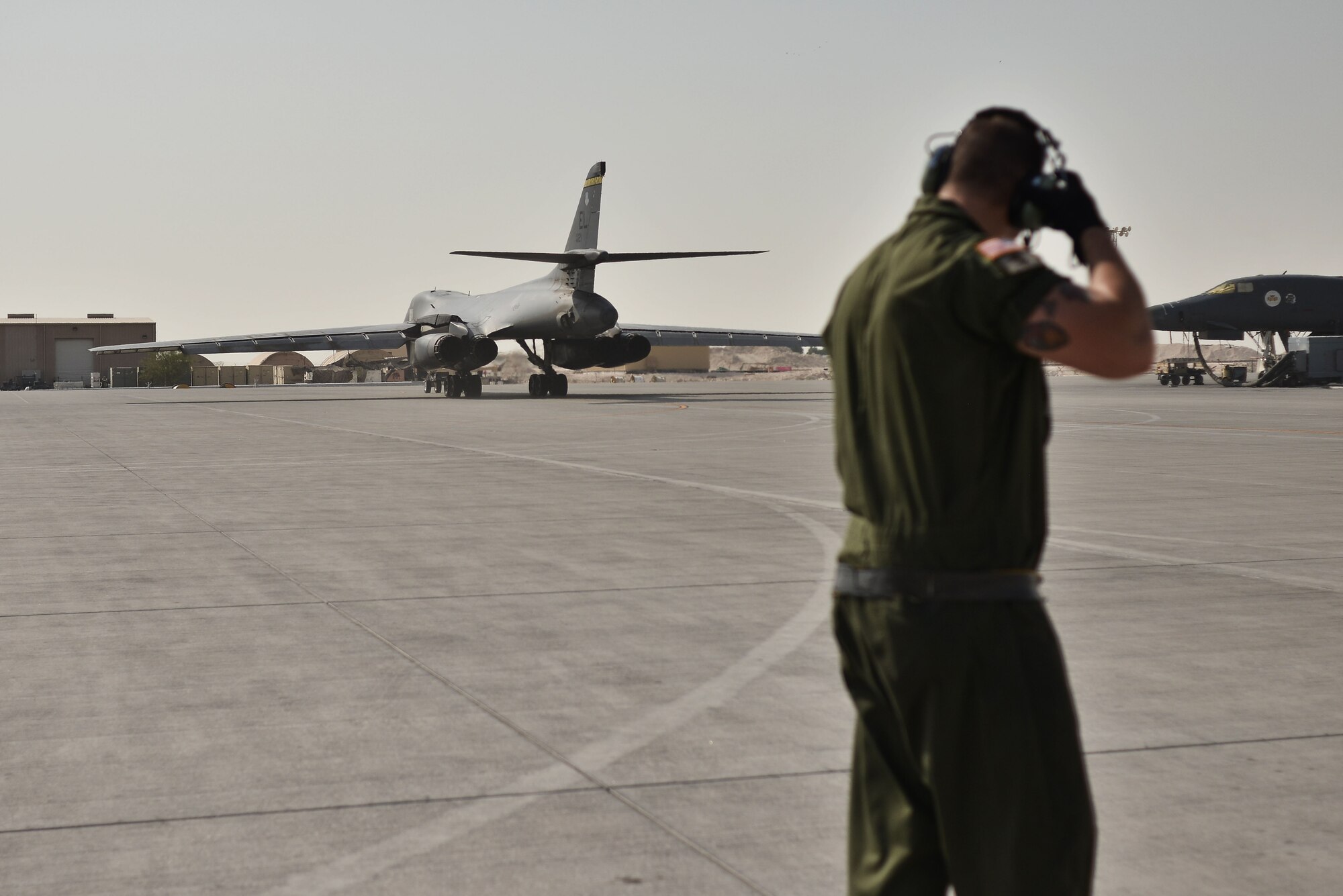 Staff Sgt. Bryant, 28th Aircraft Maintenance Squadron crew chief, watches as his B-1 bomber moves towards the flightline for take-off Sept. 22, 2015 at Al Udeid Air Base, Qatar. Bryant was deployed out of Ellsworth Air Force Base, S.D. (U.S. Air Force photo by Staff Sgt. Alexandre Montes/Released)