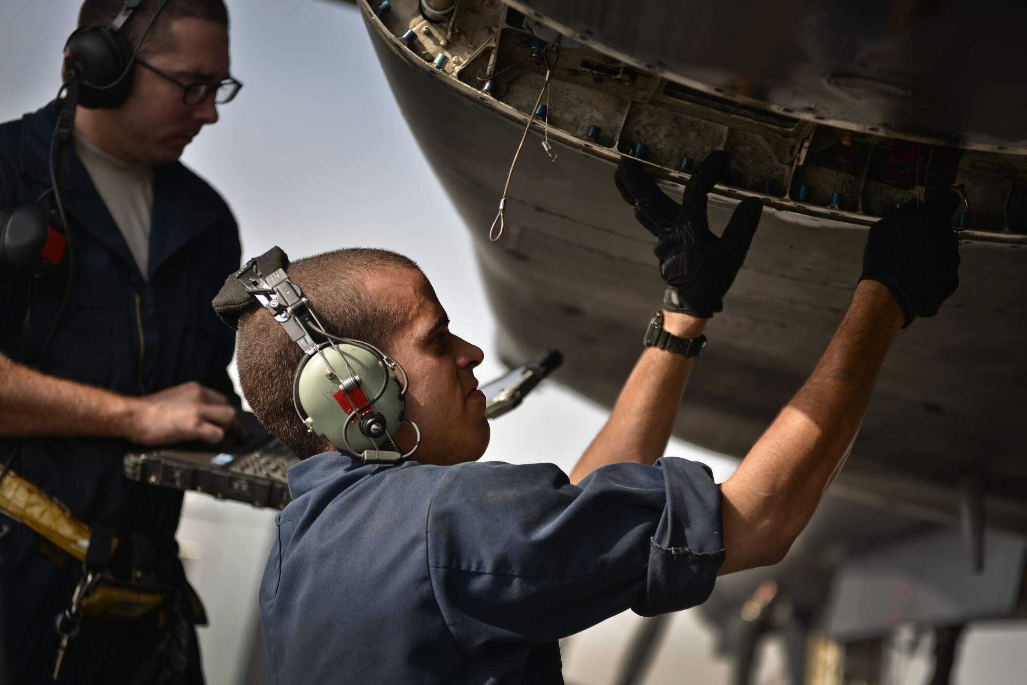 Airmen 1st Class Bobby and Brian, 28th Aircraft Maintenance Squadron crew chiefs, read through their technical orders during preventative maintenance on a B-1 bomber Sept. 22, 2015 at Al Udeid Air Base, Qatar. The two Airmen were deployed from Ellsworth Air Force Base, S.D. (U.S. Air Force photo by Staff Sgt. Alexandre Montes/Released)
