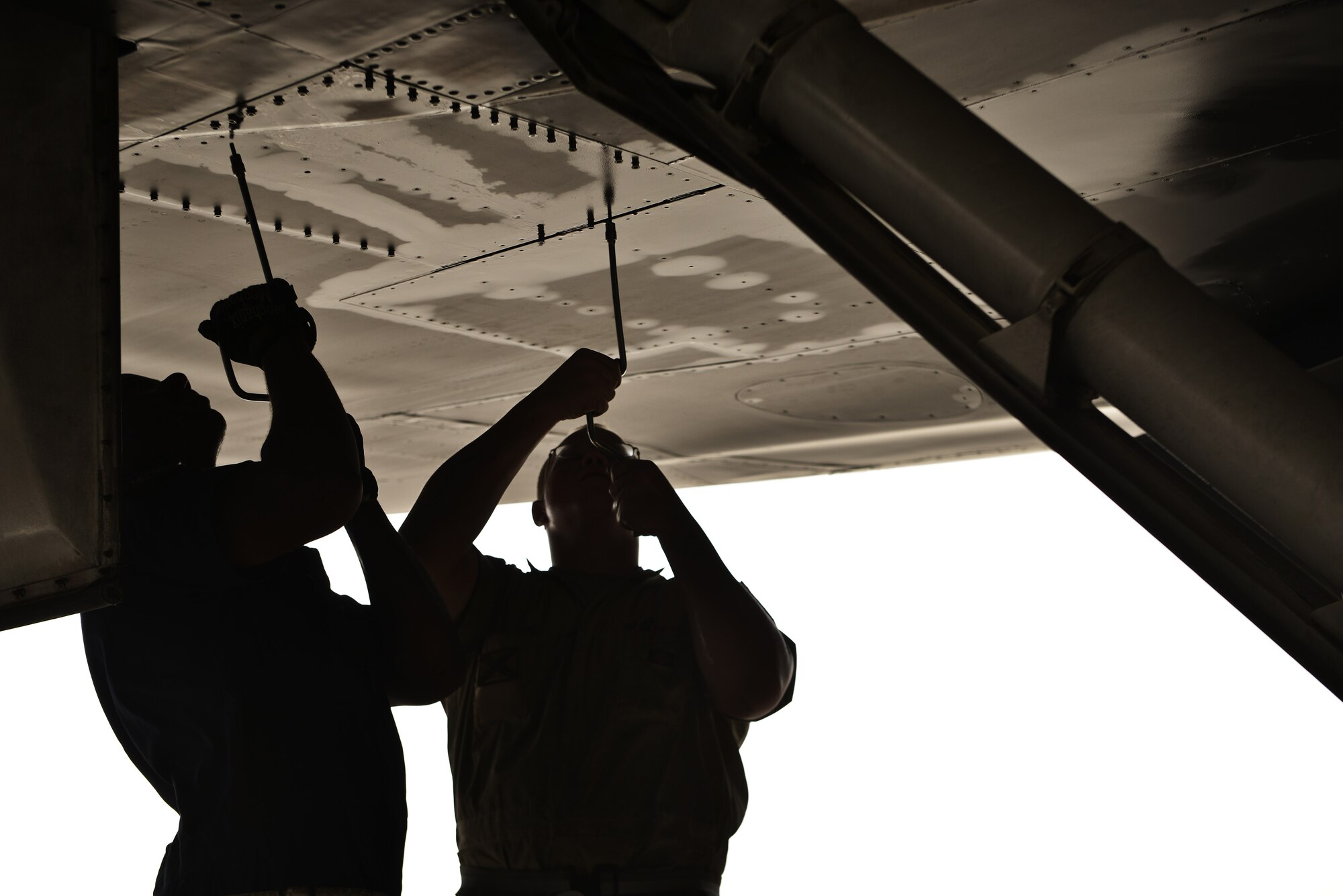 Tech. Sgt. Nasir and Airman 1st Class James, 28th Aircraft Maintenance Squadron crew chiefs, remove a panel underneath a B-1 bomber to check for leaks as part of a final pre-flight inspection Sept. 22, 2015 at Al Udeid Air Base, Qatar. Nasir and James were deployed from Ellsworth Air Force Base, S.D. (U.S. Air Force photo by Staff Sgt. Alexandre Montes/Released)