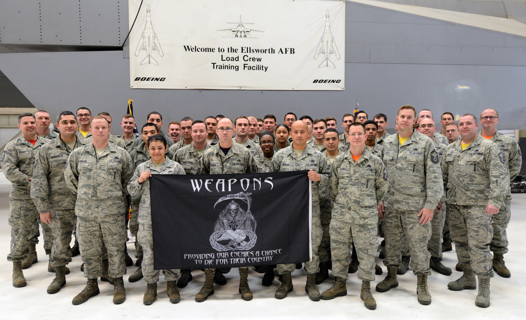 Members of the 28th Aircraft Maintenance Squadron pose with their squadron banner at Ellsworth Air Force Base, S.D., Jan. 29, 2016. 28th AMXS weapons load crew Airmen enable Ellsworth’s B-1 fleet to deliver critical air presence and precision strike capabilities worldwide. (U.S. Air Force photo by Airman Donald Knechtel/Released)