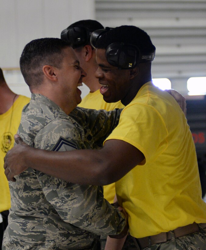 Airman 1st Class Damian Wiseman, 28th Aircraft Maintenance Squadron weapons load crew member, right, is congratulated by Senior Master Sgt. Justin Price, 28th AMXS weapons flight chief, after winning a quarterly load crew competition at Ellsworth Air Force Base, S.D., Jan. 29, 2016. The groups were evaluated on technical procedures, safety and reliability issues. (U.S. Air Force photo by Airman Donald Knechtel/Released)