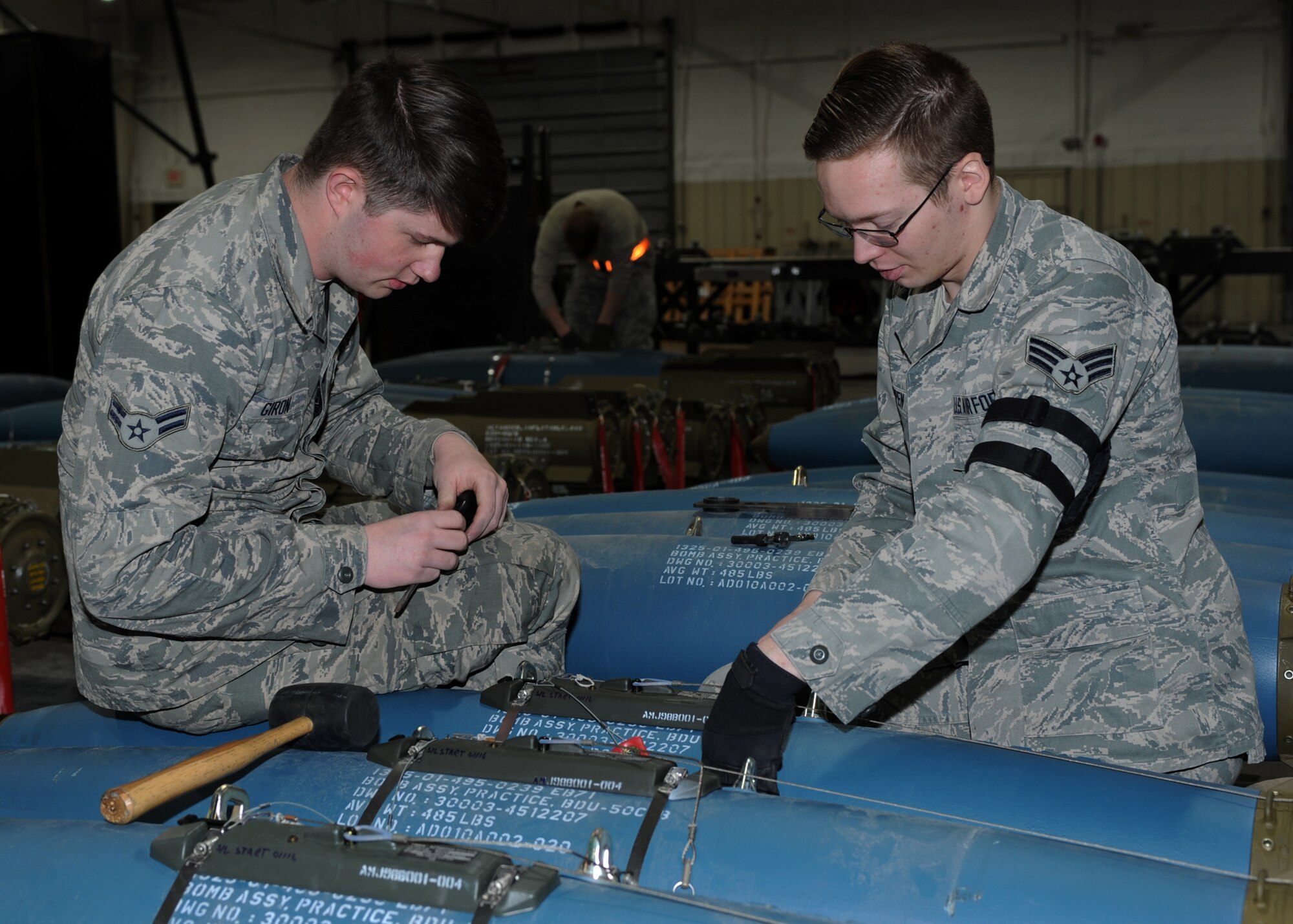 Airman 1st Class Dylan Giron, left, and Senior Airman Jesse Knappen, 28th Munitions Squadron crew members, apply a lanyard to a bomb dummy unit-50 as part of the delayed timer unit during a training session at Ellsworth Air Force Base, S.D., Jan. 19, 2016. The 28th MUNS consists of more than 240 Airmen working in four flights, providing support for the 27 B-1 bombers assigned to Ellsworth AFB. (U.S. Air Force photo by Airman 1st Class Denise M. Nevins/Released)