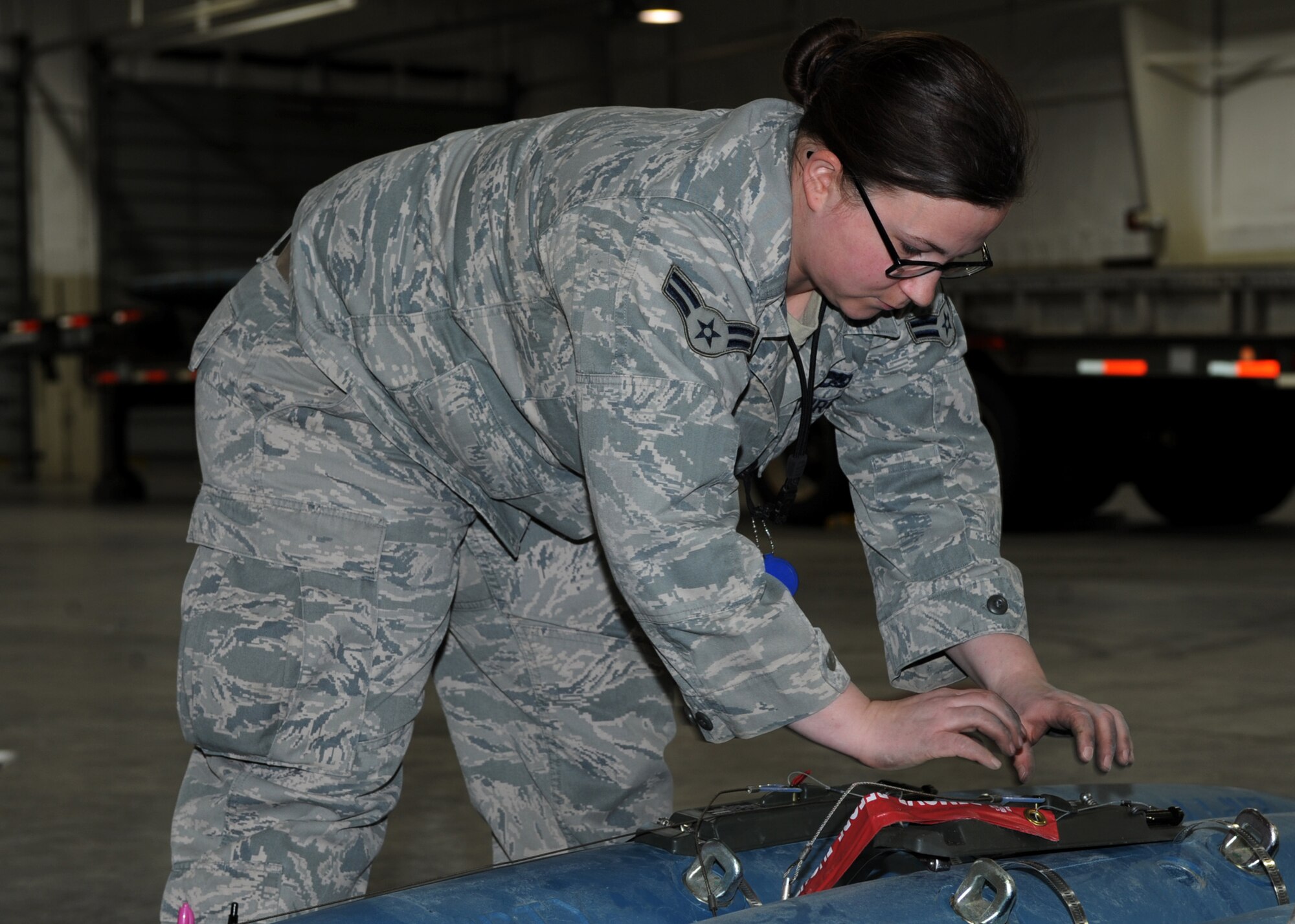Airman 1st Class Lauren Sessums, 28th Munitions Squadron crew member, installs a delayed timer unit to a bomb dummy unit-50 during a training session at Ellsworth Air Force Base, S.D., Jan. 19, 2016. The DTU allows a pillow parachute to be deployed from the munition, enabling the bomb to detonate at lower altitudes for a close ground attack. (U.S. Air Force photo by Airman 1st Class Denise M. Nevins/Released)