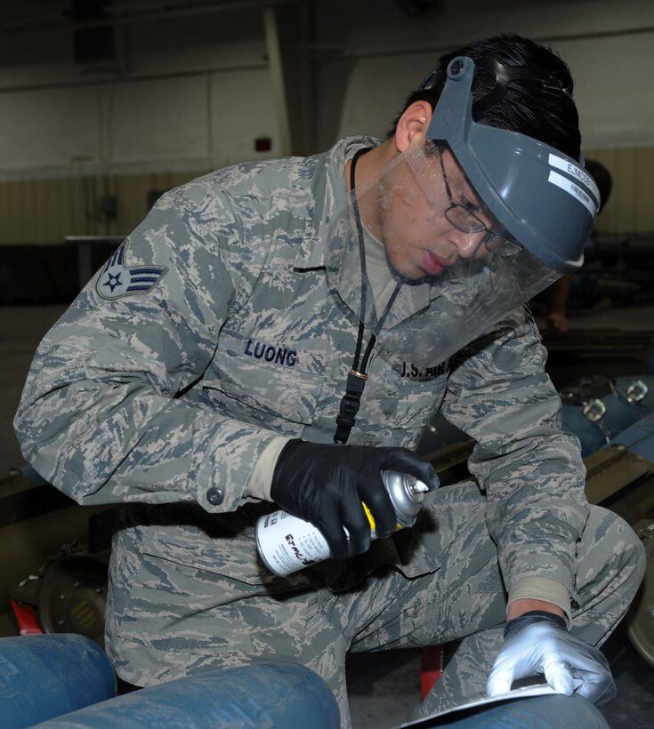 Senior Airman John Luong, 28th Munitions Squadron munitions inspector, spray-paints a weapon serial number on a bomb dummy unit-50 during a training session at Ellsworth Air Force Base, S.D., Jan. 19, 2016. The WSN is used to label munitions from different pallets so if there was a malfunction it could be easier to determine if it was a technical error or factory issue. (U.S. Air Force photo by Airman 1st Class Denise M. Nevins/Released)