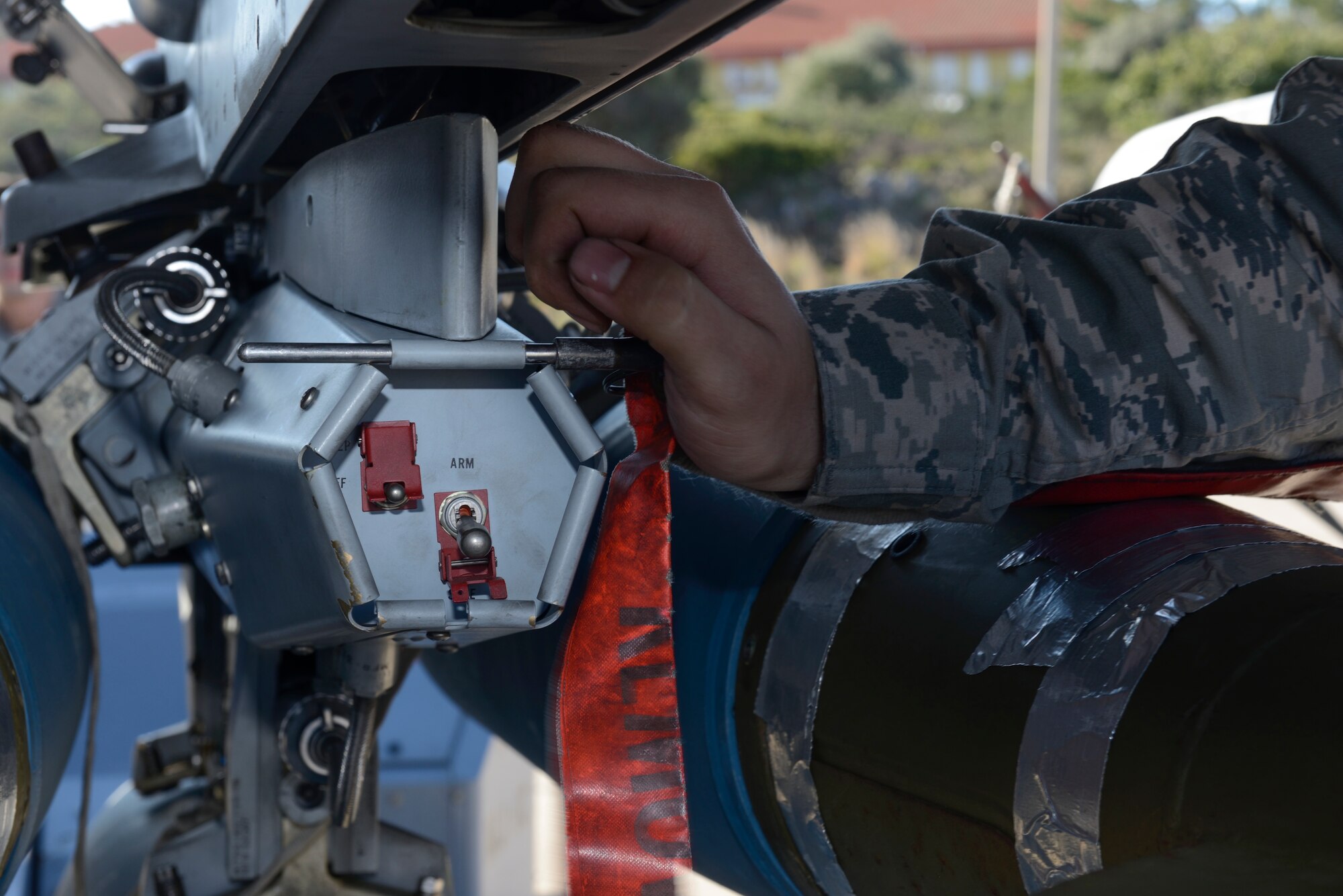 U.S. Air Force Airman 1st Class Austin Holden, a weapons load crew member assigned to the 480th Expeditionary Fighter Squadron, Spangdahlem Air Base, Germany, places a locking pin on a bomb rack attached to an F-16 Fighting Falcon fighter aircraft during a flying training deployment at Souda Bay, Greece, Jan. 29, 2016. The aircraft conducted range training as part of a bilateral deployment between the Greek and U.S. air forces to develop interoperability and cohesion between the partnering nations. (U.S. Air Force photo by Staff Sgt. Christopher Ruano/Released)