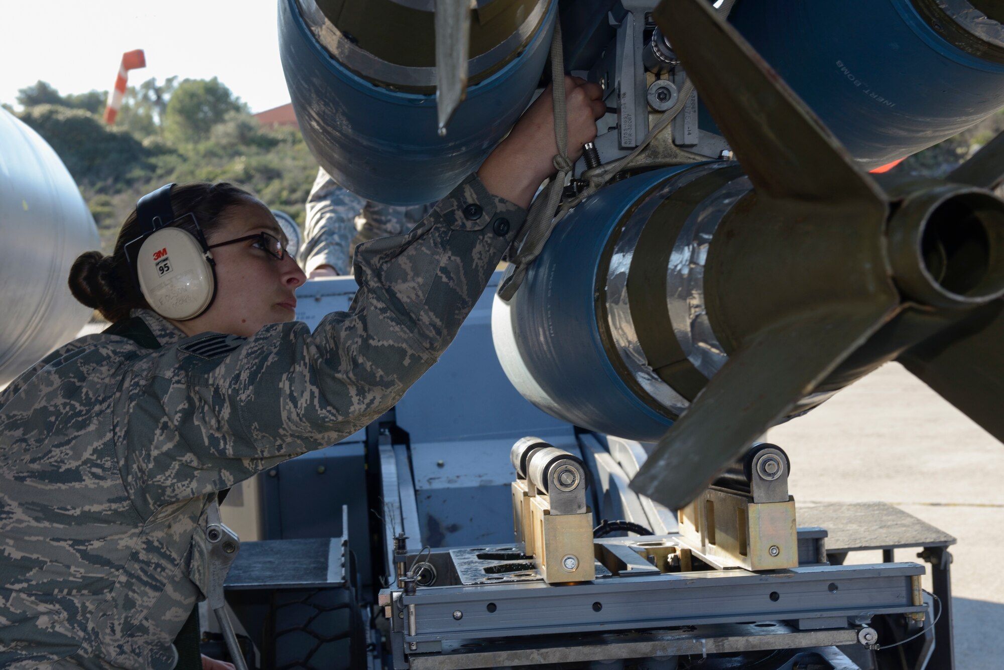 U.S. Air Force Staff Sgt. Faith Olson, a weapons load crew chief assigned to the 480th Expeditionary Fighter Squadron, Spangdahlem Air Base, Germany, secures a Bomb Drop Unit-50 to an F-16 Fighting Falcon fighter aircraft during a flying training deployment at Souda Bay, Greece, Jan. 29, 2016. The flight training took place on the northwest bay of Crete, alongside the island's White Mountain range and over the Mediterranean Sea. (U.S. Air Force photo by Staff Sgt. Christopher Ruano/Released)