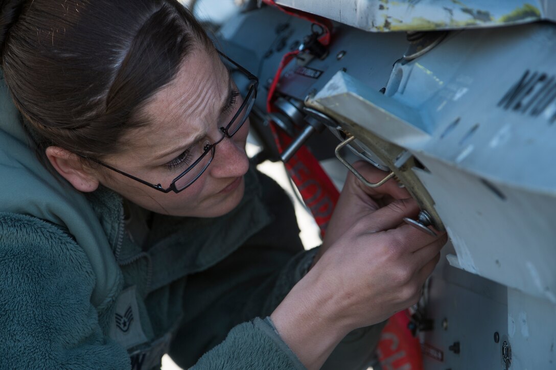 U.S. Air Force Staff Sgt. Faith Olson, a weapons load crew chief assigned to the 480th Expeditionary Fighter Squadron, Spangdahlem Air Base, Germany, loosens a bolt in preparation to mount a Bomb Drop Unit-50 onto an F-16 Fighting Falcon fighter aircraft during a flying training deployment at Souda Bay, Greece, Jan. 29, 2016. The training allows the NATO partners to fly together to strengthen their joint military capability. (U.S. Air Force photo by Staff Sgt. Christopher Ruano/Released)