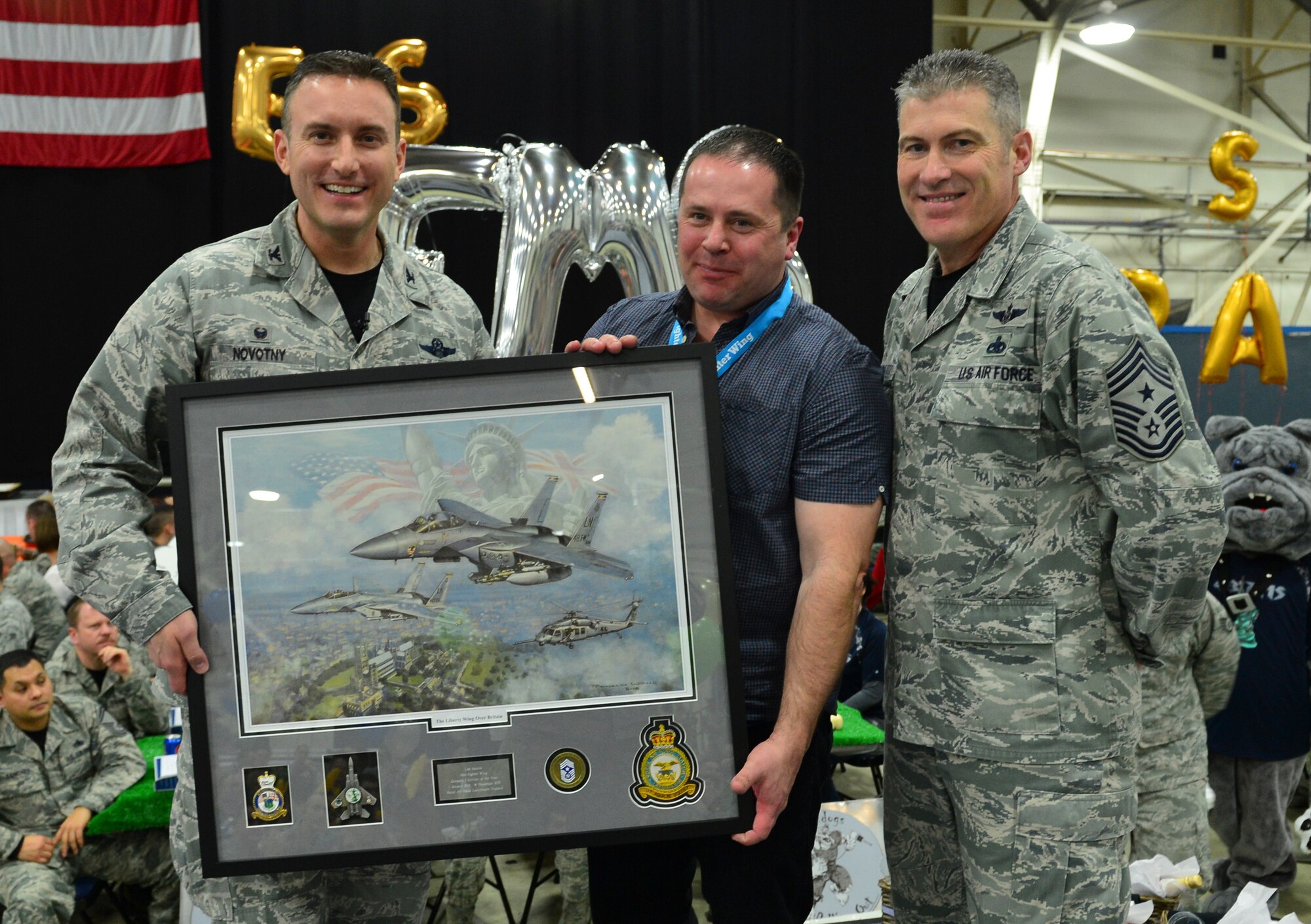 Col. Robert Novotny, 48th Fighter Wing commander, and Chief Master Sgt. David O’Hara, 48th Fighter Wing command chief, present the Category One Civilian of the Year Award to Mr. Lee Ackers, 48th Maintenance Group, during the 48th FW Annual Awards Banquet at Hangar 7, Feb. 5, 2016. Airmen were recognized across 13 categories, representing the spectrum of the Liberty Wing. (U.S. Air Force photo by Staff Sgt. Stephanie Longoria)