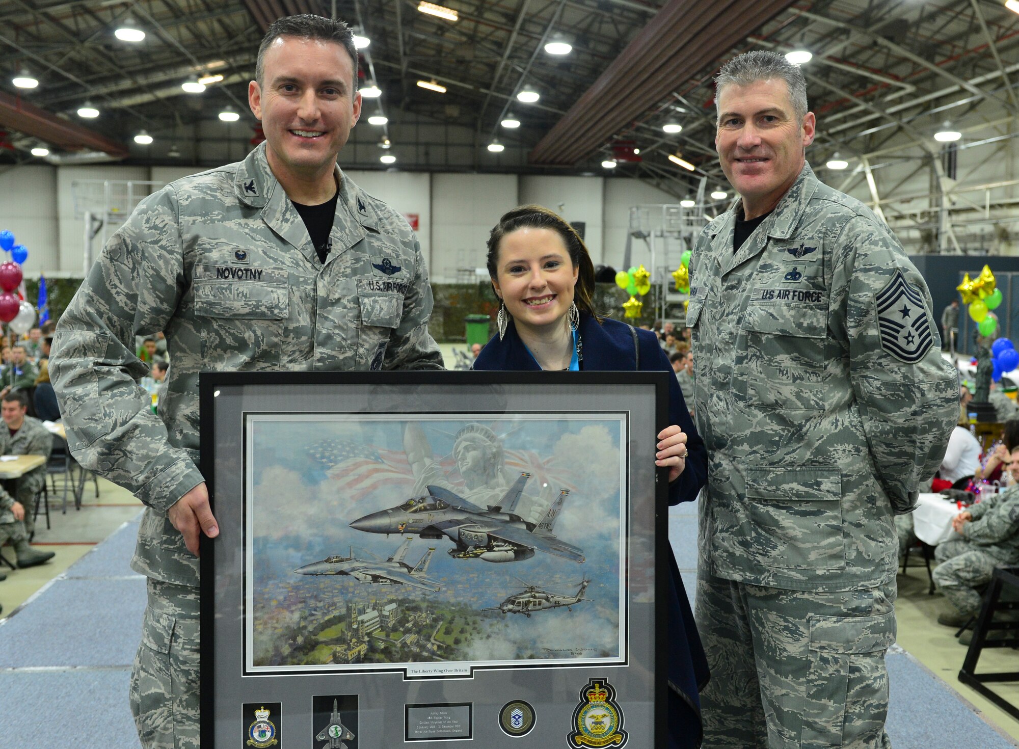 Col. Robert Novotny, 48th Fighter Wing commander, and Chief Master Sgt. David O’Hara, 48th Fighter Wing command chief, present the Category Two Volunteer of the Year Award to Ms. Ashley Smith, 48th Fighter Wing, Wing Staff Agencies, during the 48th FW Annual Awards Banquet at Hangar 7, Feb. 5, 2016. Airmen were recognized across 13 categories, representing the spectrum of the Liberty Wing. (U.S. Air Force photo by Staff Sgt. Stephanie Longoria)