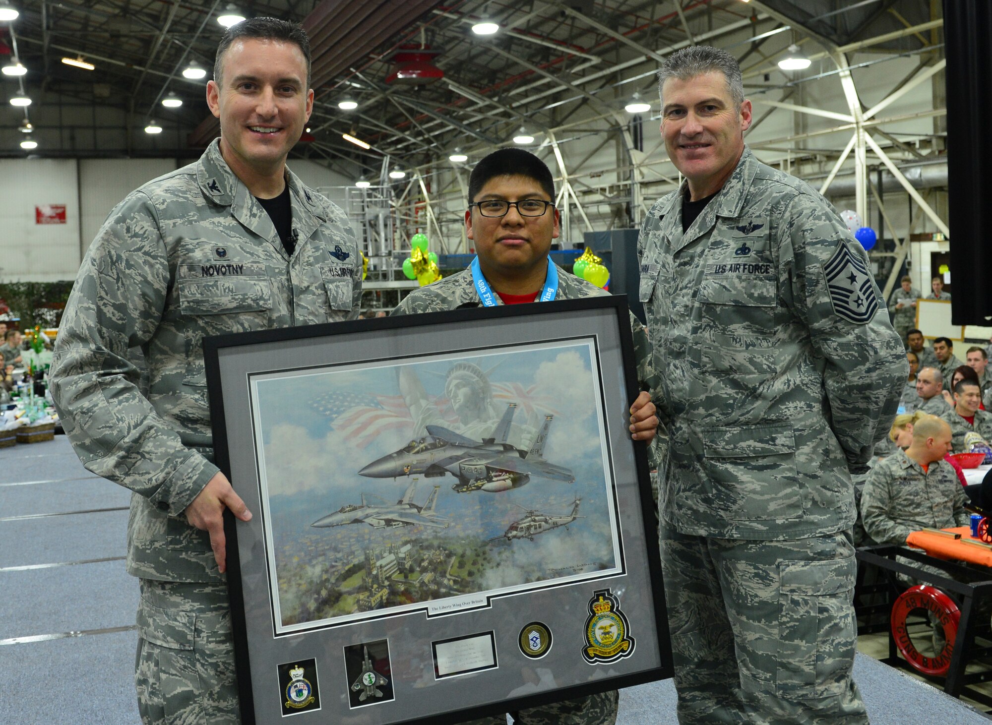 Col. Robert Novotny, 48th Fighter Wing commander, and Chief Master Sgt. David O’Hara, 48th Fighter Wing command chief, present the Category One Volunteer of the Year Award to Staff Sgt. Henry Lux, 48th Medical Group, during the 48th FW Annual Awards Banquet at Hangar 7, Feb. 5, 2016. Airmen were recognized across 13 categories, representing the spectrum of the Liberty Wing. (U.S. Air Force photo by Staff Sgt. Stephanie Longoria)