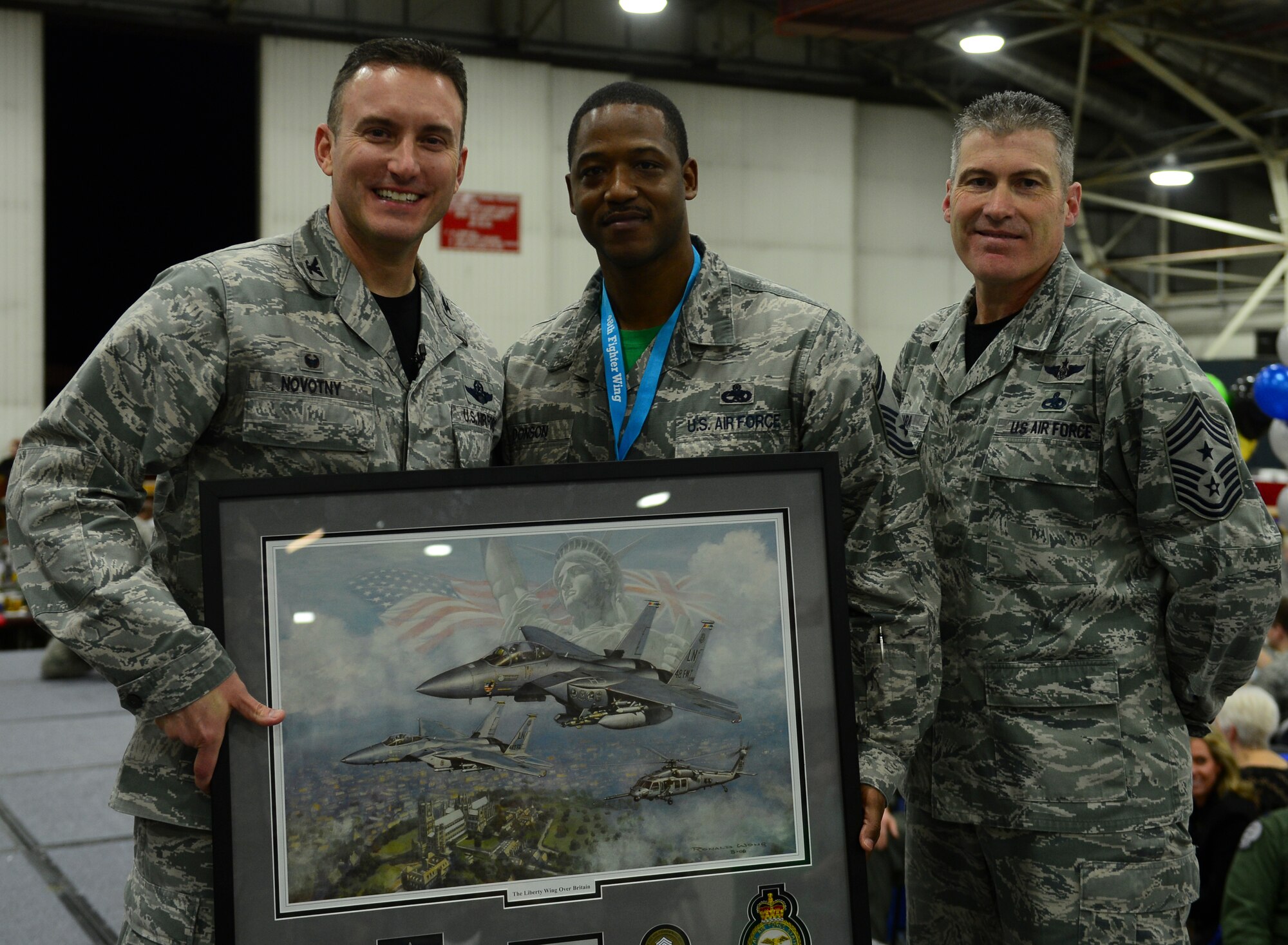 Col. Robert Novotny, 48th Fighter Wing commander, and Chief Master Sgt. David  O’Hara, 48th Fighter Wing command chief, present the Senior NCO of the Year Award to Senior Master Sgt. Terrance Donson, 48th Maintenance Group, during the 48th FW Annual Awards Banquet at Hangar 7, Feb. 5, 2016. Airmen were recognized across 13 categories, representing the spectrum of the Liberty Wing. (U.S. Air Force photo by Senior Airman Dawn Weber)