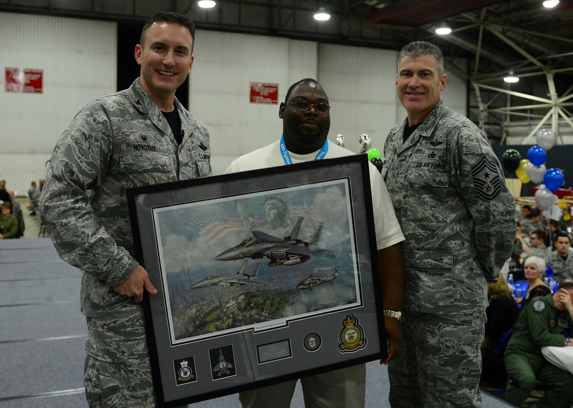 Col. Robert Novotny, 48th Fighter Wing commander, and Chief Master Sgt. David O’Hara, 48th Fighter Wing command chief, present the Civilian Category Four of the Year Award to Mr. James Smith, 48th Maintenance Group, during the 48th FW Annual Awards Banquet at Hangar 7, Feb. 5, 2016. Airmen were recognized across 13 categories, representing the spectrum of the Liberty Wing. (U.S. Air Force photo by Senior Airman Dawn M. Weber)