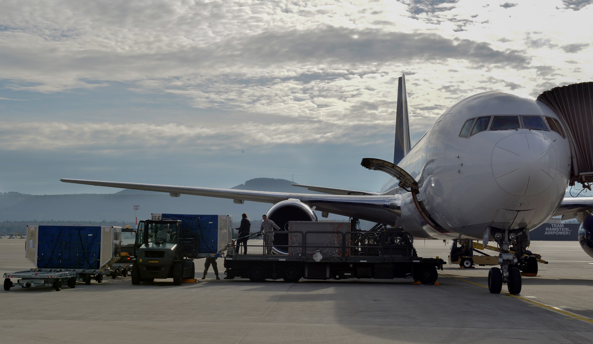 Airmen from the 721st Aerial Port Squadron load cargo into a Boeing 767 Jan. 27, 2016, at Ramstein Air Base, Germany. Once a plane arrives, Airmen unload the cargo belonging to passengers on the inbound flight and quickly fill the storage with the containers full of the outbound flight passengers’ belongings. (U.S. Air Force photo/Airman 1st Class Lane T. Plummer)