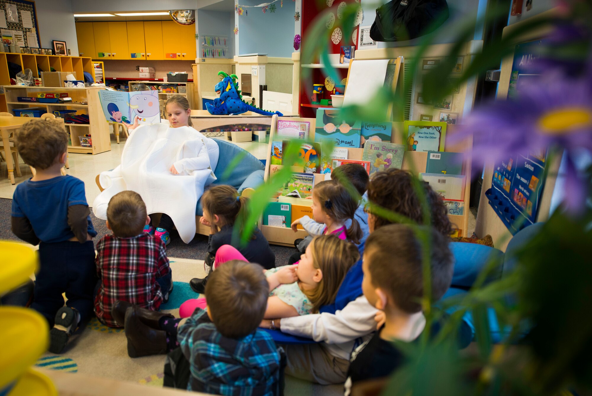 Samantha Holt, daughter of Capt. (Dr.) Melissa Holt, 779th Dental Squadron dentist, reads to children during a National Children's Dental Health Month event at the Child Development Center at Joint Base Andrews, Md., Feb. 5, 2016. During the event, members from the 779th DS spoke with children about proper brushing techniques, effects of too much sugar and healthy foods. (U.S. Air Force photo by Staff Sgt. Chad C. Strohmeyer/Released)