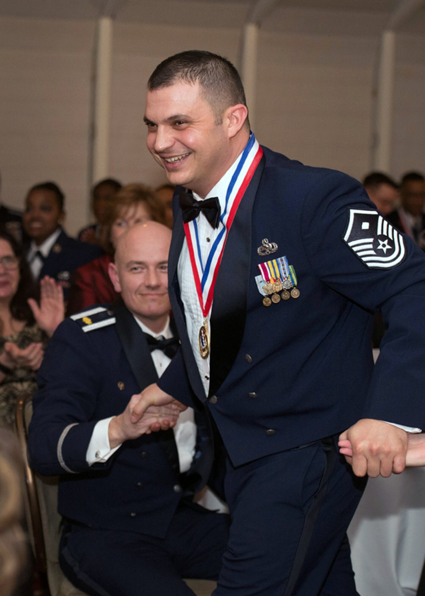 Master Sgt. Nicholas A. Souza, 66th Comptroller Squadron first sergeant, shakes hands with 66th Air Base Group Annual Awards Banquet attendees after he was named the First Sergeant of the Year Feb. 4 at the Minuteman Commons. More than 200 members of the group, including friends and family, attended the ceremony. Col. David R. Dunklee, 66 ABG commander, and Hanscom Command Chief Master Sgt. Patricia L. Hickey presented the individual and team winners with their award. (U.S. Air Force photo by Jerry Saslav)

