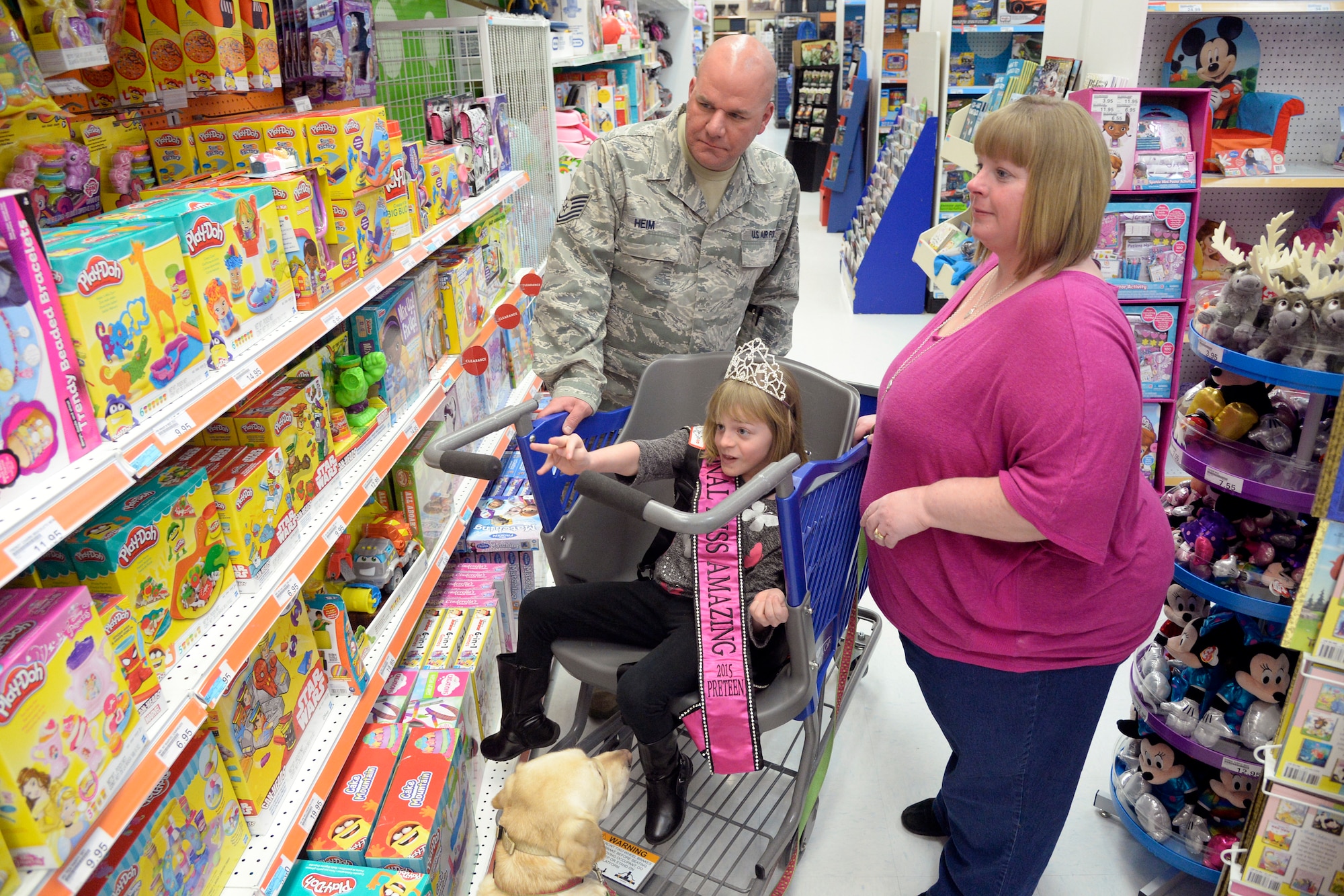 Tech. Sgt. Scott Heim, a member of the 388th Equipment Maintenance Squadron, his spouse Wendy, daughter Brieanna and family pet Emily use a Caroline’s Cart during a visit to the Base Exchange at Hill Air Force Base Feb. 4. A Caroline's Cart is built with a roomy seat and adjustable harness designed to ease the shopping experience for families with a special needs member. Hill AFB started seeking a Caroline's Cart for the base in June 2014 after hearing about the product from special needs families. The Commissary purchased one in October 2015 and it has benefited many families since. (U.S. Air Force photo by Todd Cromar)