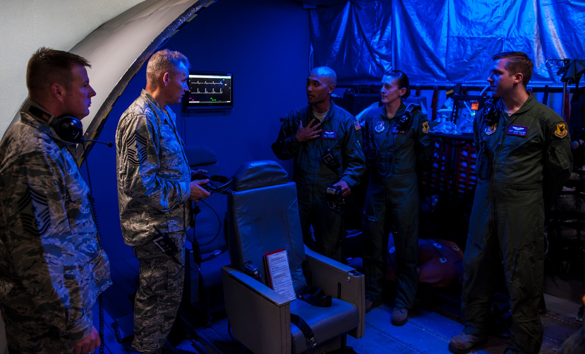 Chief Master Sgt. Jim Laurent, U.S. Forces Japan and 5th Air Force command chief master sgt., and Chief Master Sgt. Charles Hoffman, 18th Wing command chief, talk to Capt. Noel Aragona, 18th Aeromedical Evacuation Squadron medical crew, at a training simulator Feb. 5, 2016, at Kadena Air Base. Aragona explained to Laurent details of his mission requirements and training capabilities. (U.S. Air Force photo by Airman 1st Class Nick Emerick)