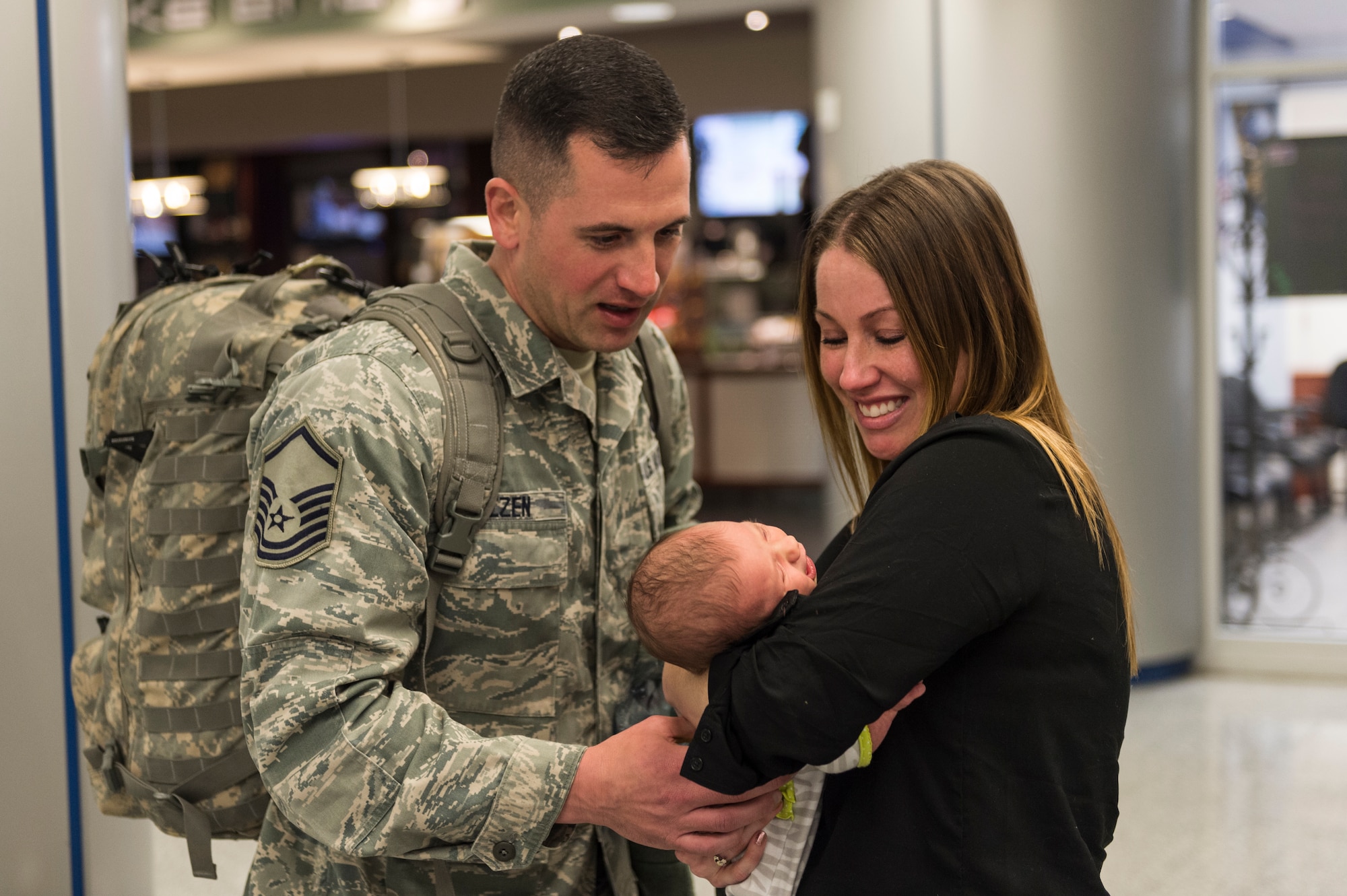 Master Sgt. Joseph Molzen, an Airman assigned to the 107th Security Forces Squadron, Niagara Falls Air Reserve Station, N.Y., gets to see his newborn daughter for the first time. Molzen was one of more than 30 Airmen from the 107th SFS to return from a six-month deployment to Southwest Asia, Feb. 4-5, 2016. (U.S. Air National Guard photo by Staff Sgt. Ryan Campbell/Released)